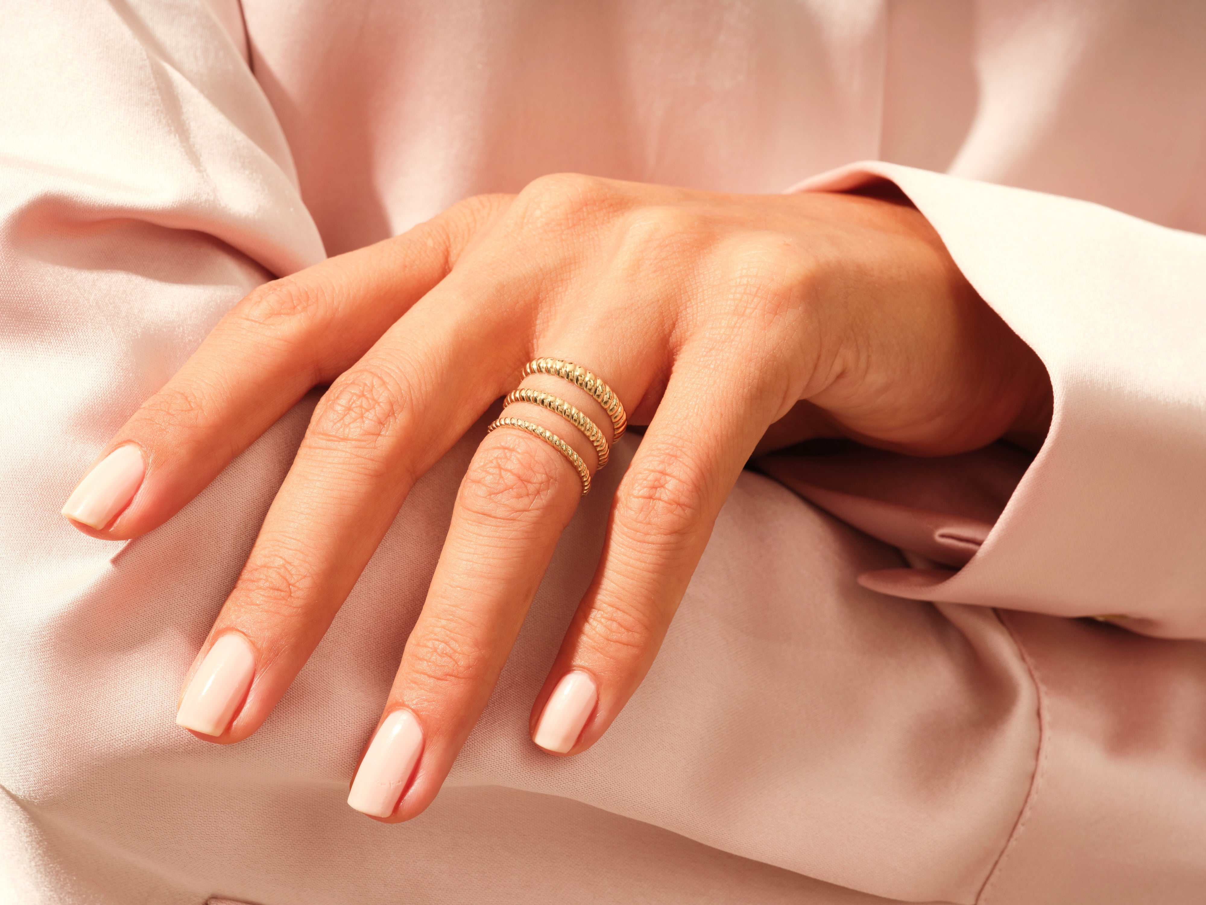 Gold stackable rings on a hand, jewelry product photography