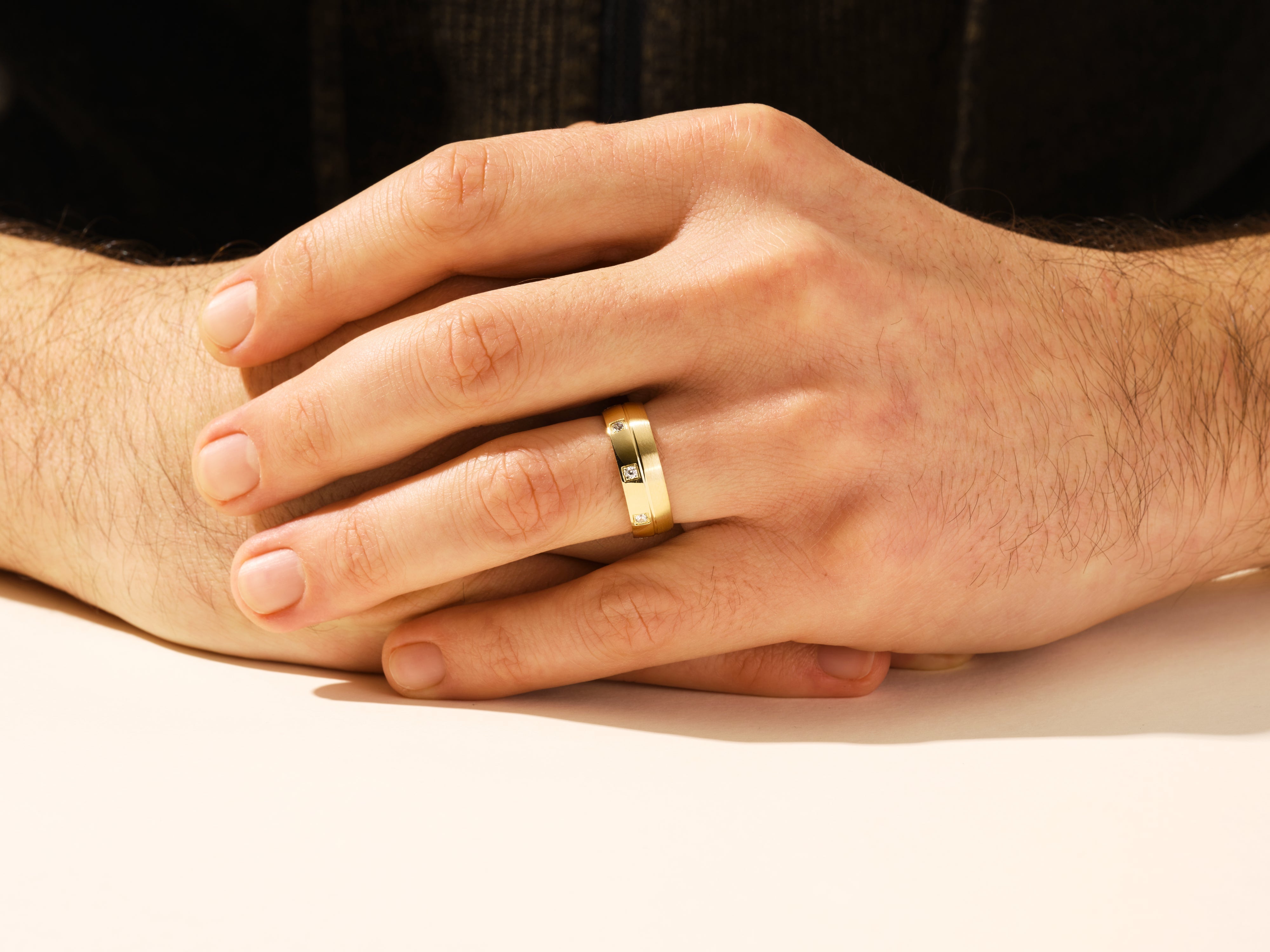 Gold wedding band with diamonds on a man's hand