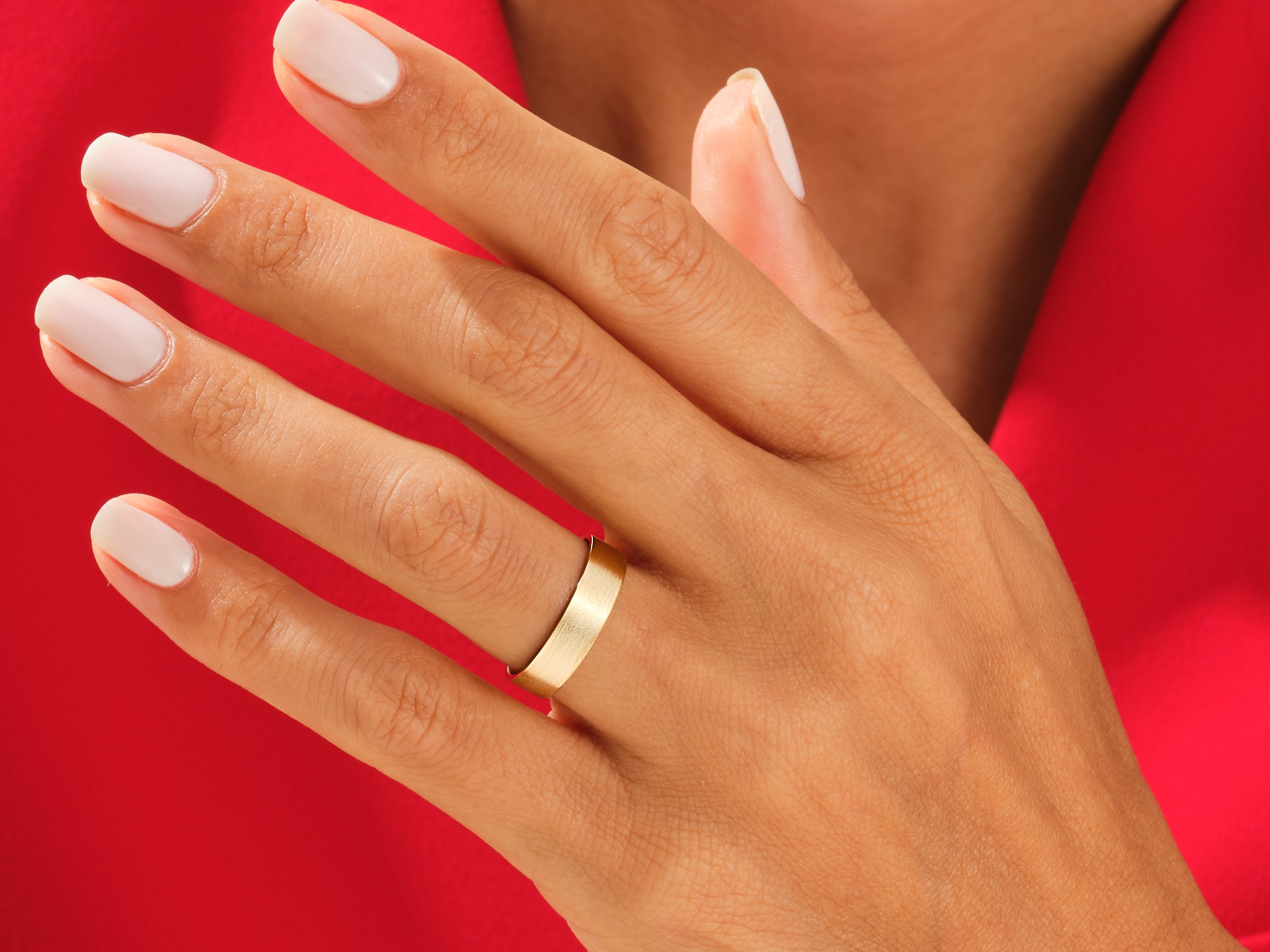 Gold wedding band on a hand, jewelry photography