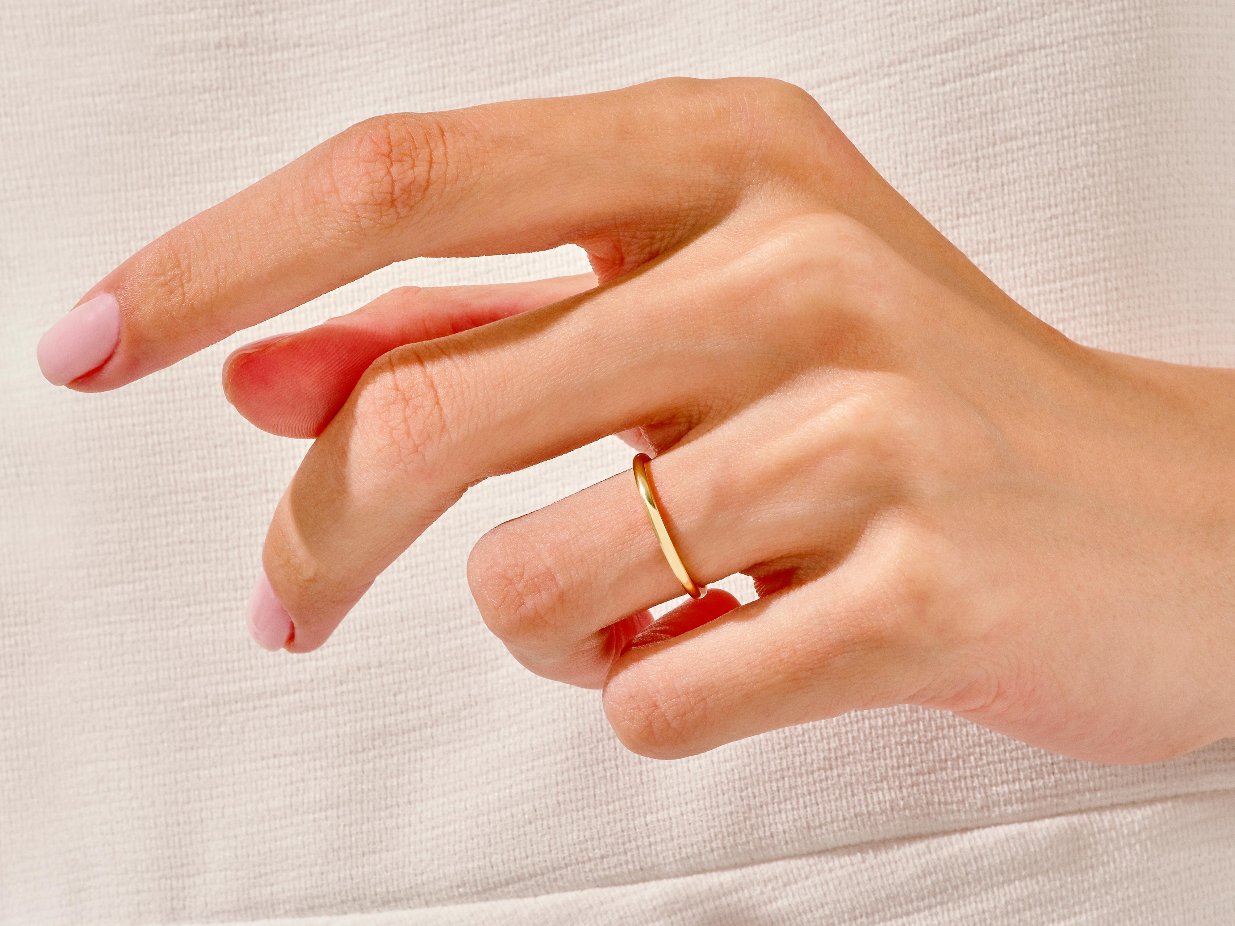 Delicate gold ring on a hand, showcasing fine jewelry craftsmanship