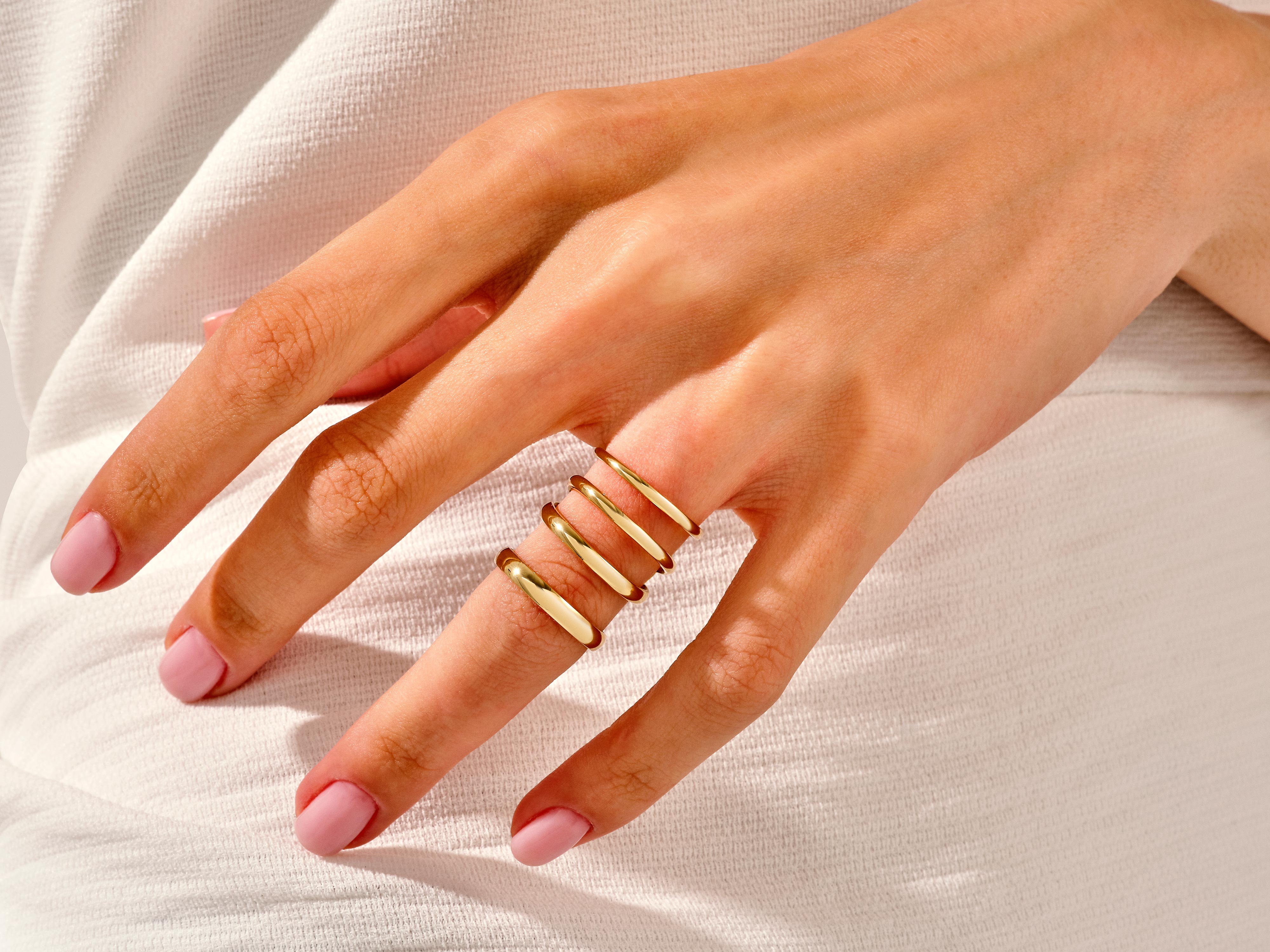 Gold stackable rings on hand, fine jewelry for women