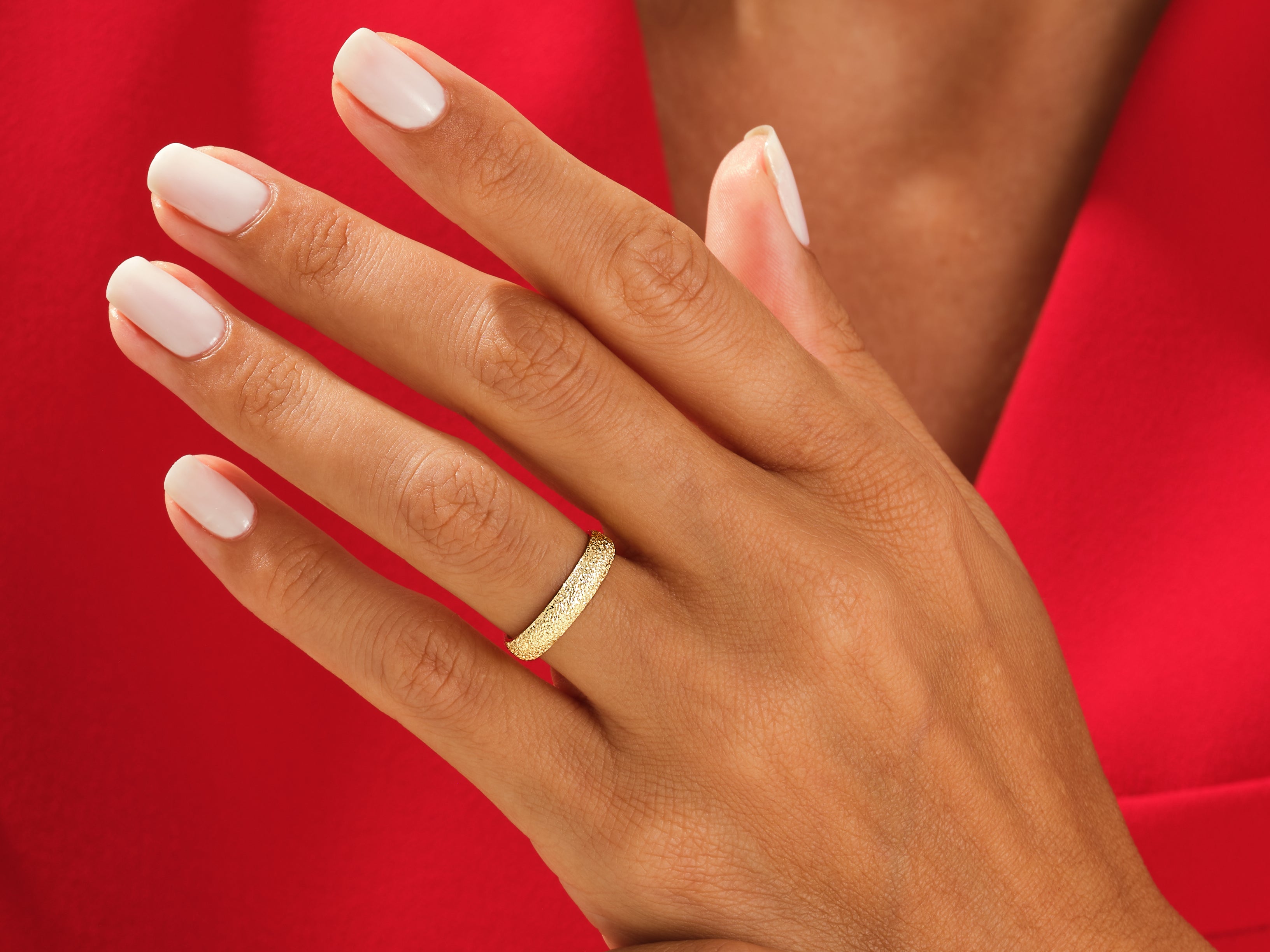 Gold textured ring on a hand, jewelry product shot