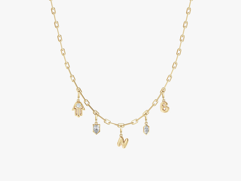 Gold necklace with charms: Hamsa, letters, and diamonds