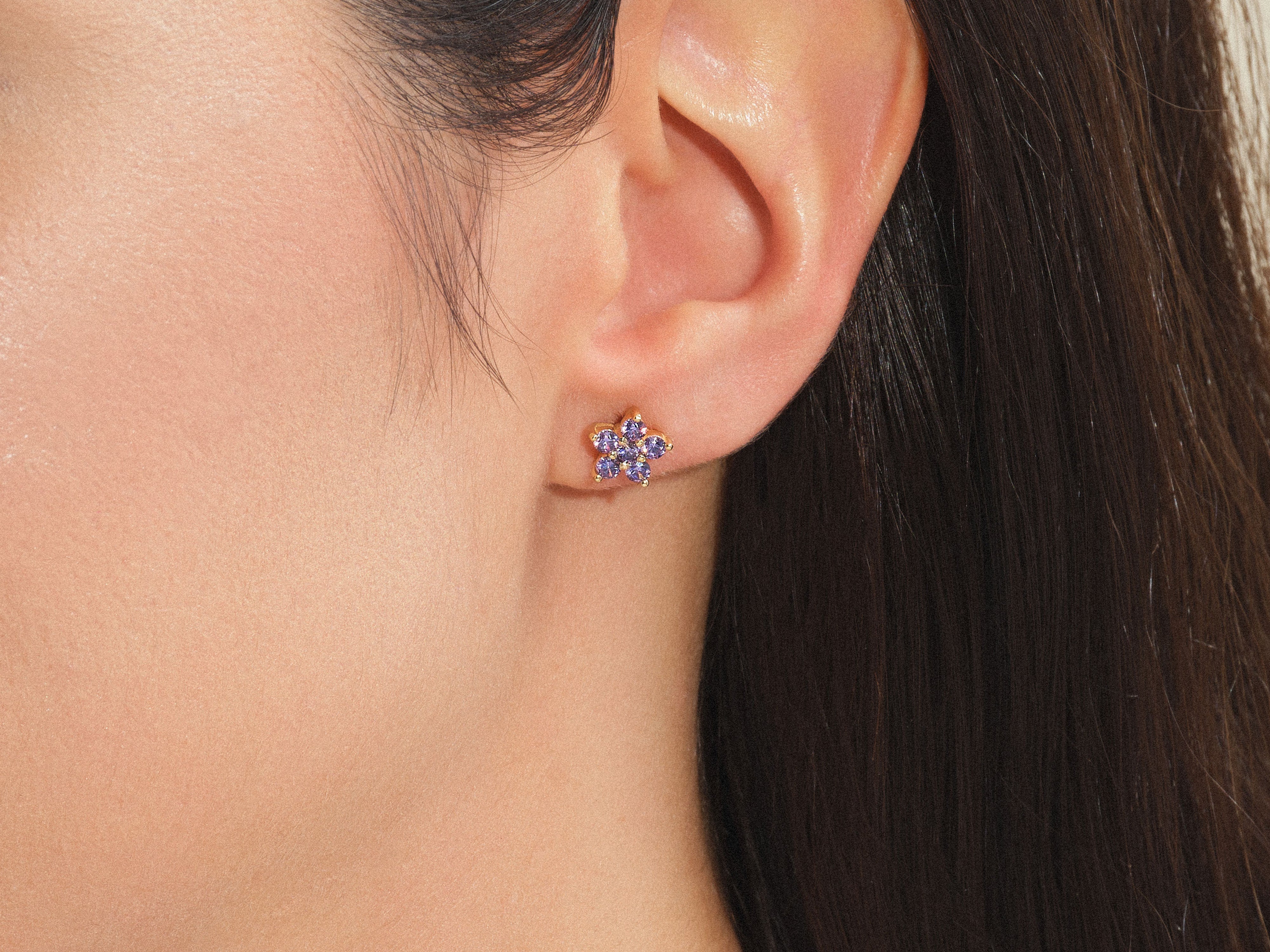 Gold flower stud earring with purple gemstones