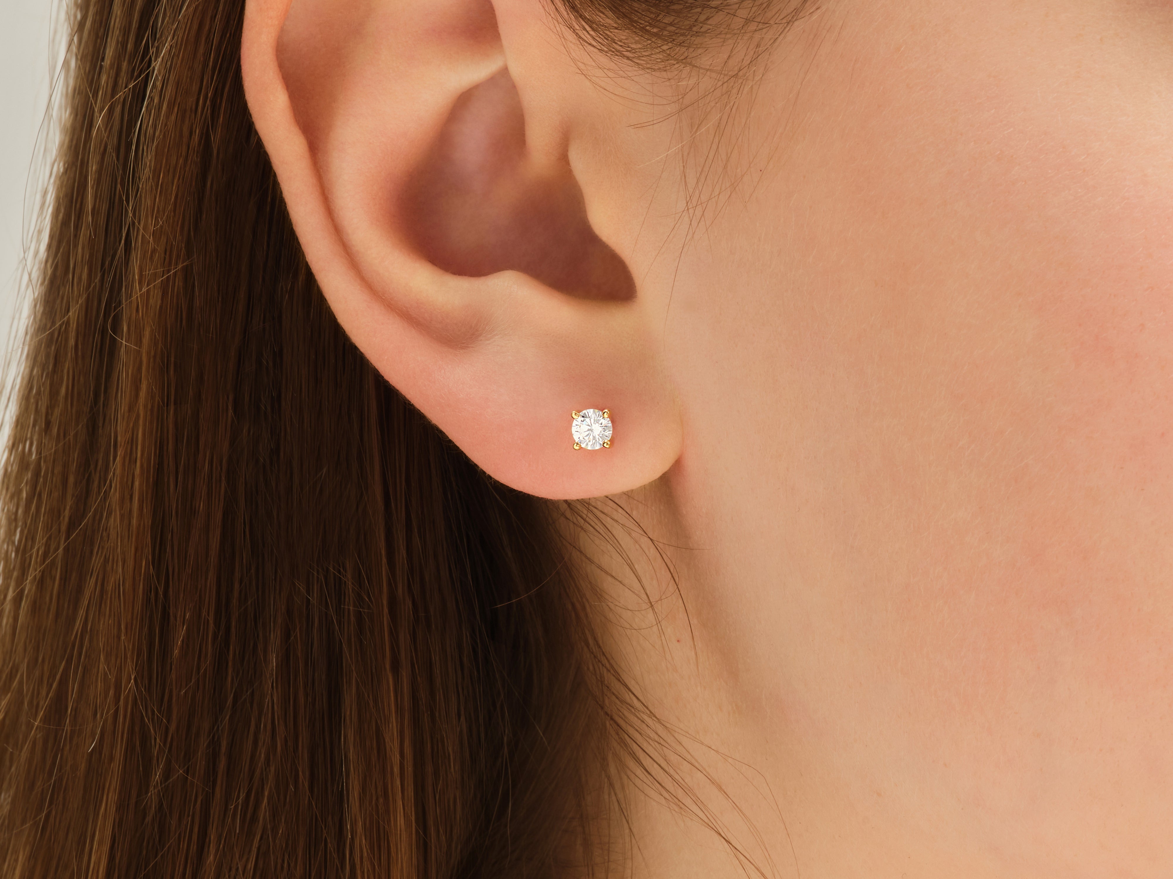 Gold diamond stud earring on a woman's ear