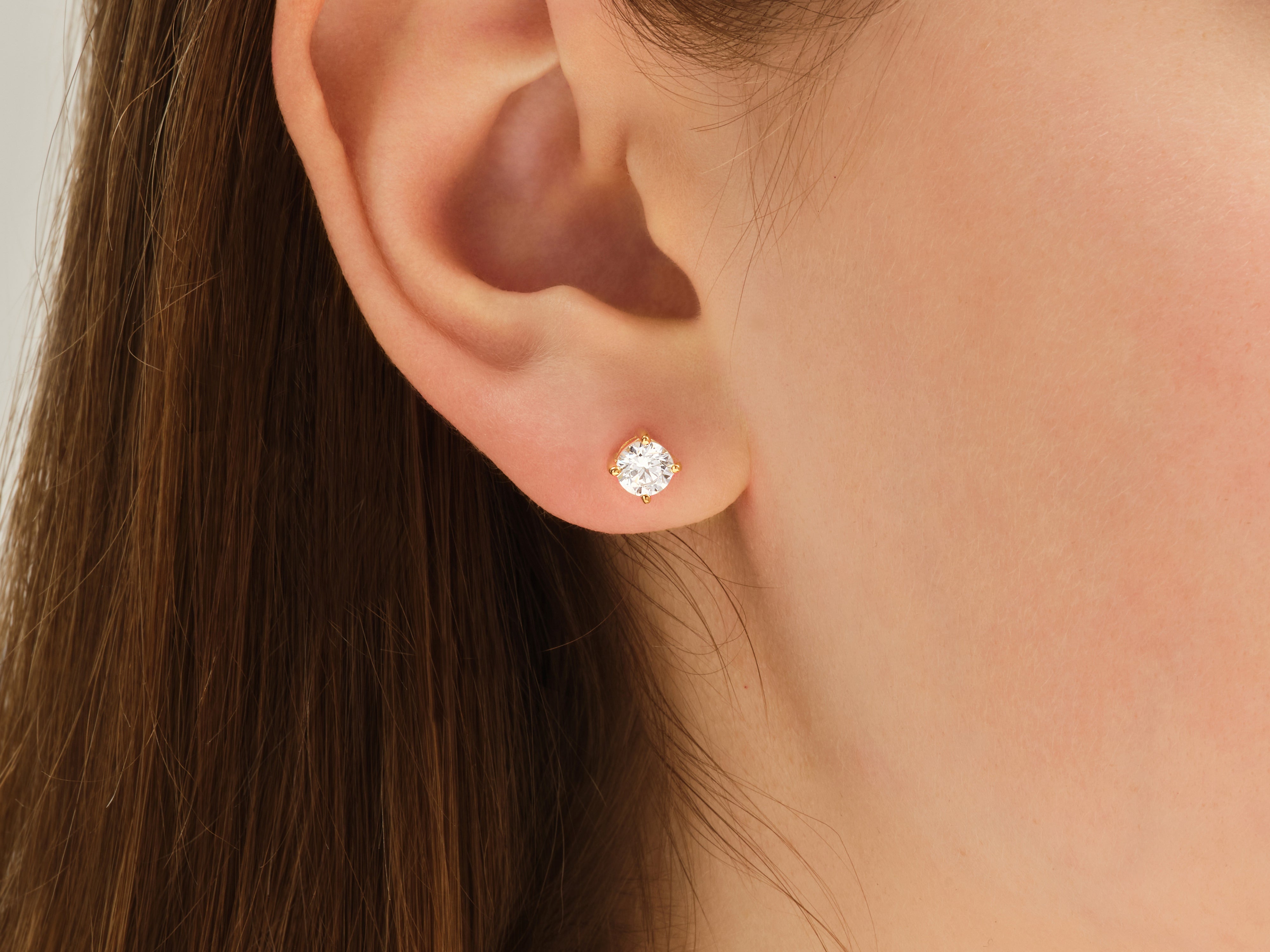 Gold diamond stud earring on a woman's ear