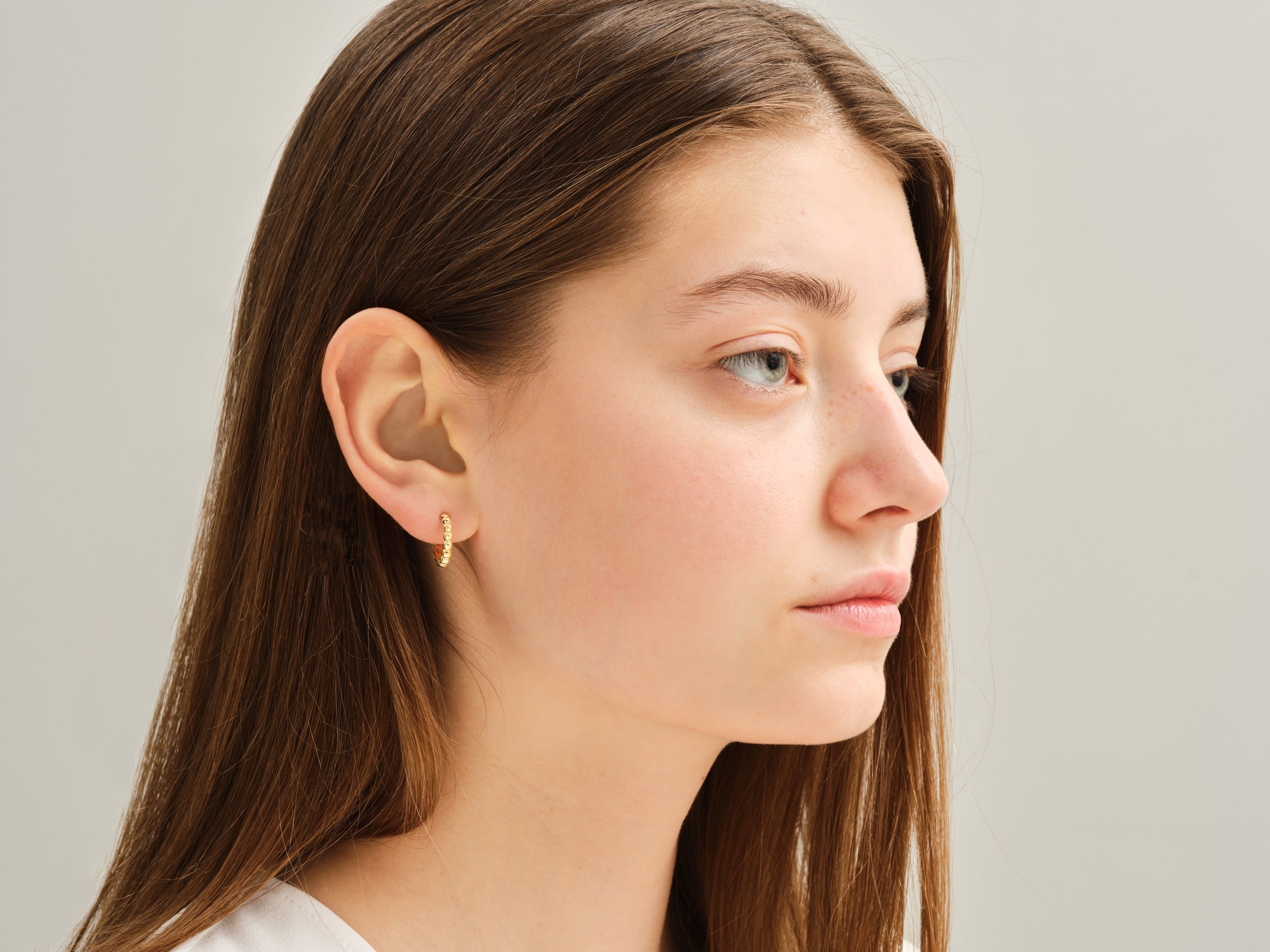 Gold beaded hoop earring on model, jewelry photography