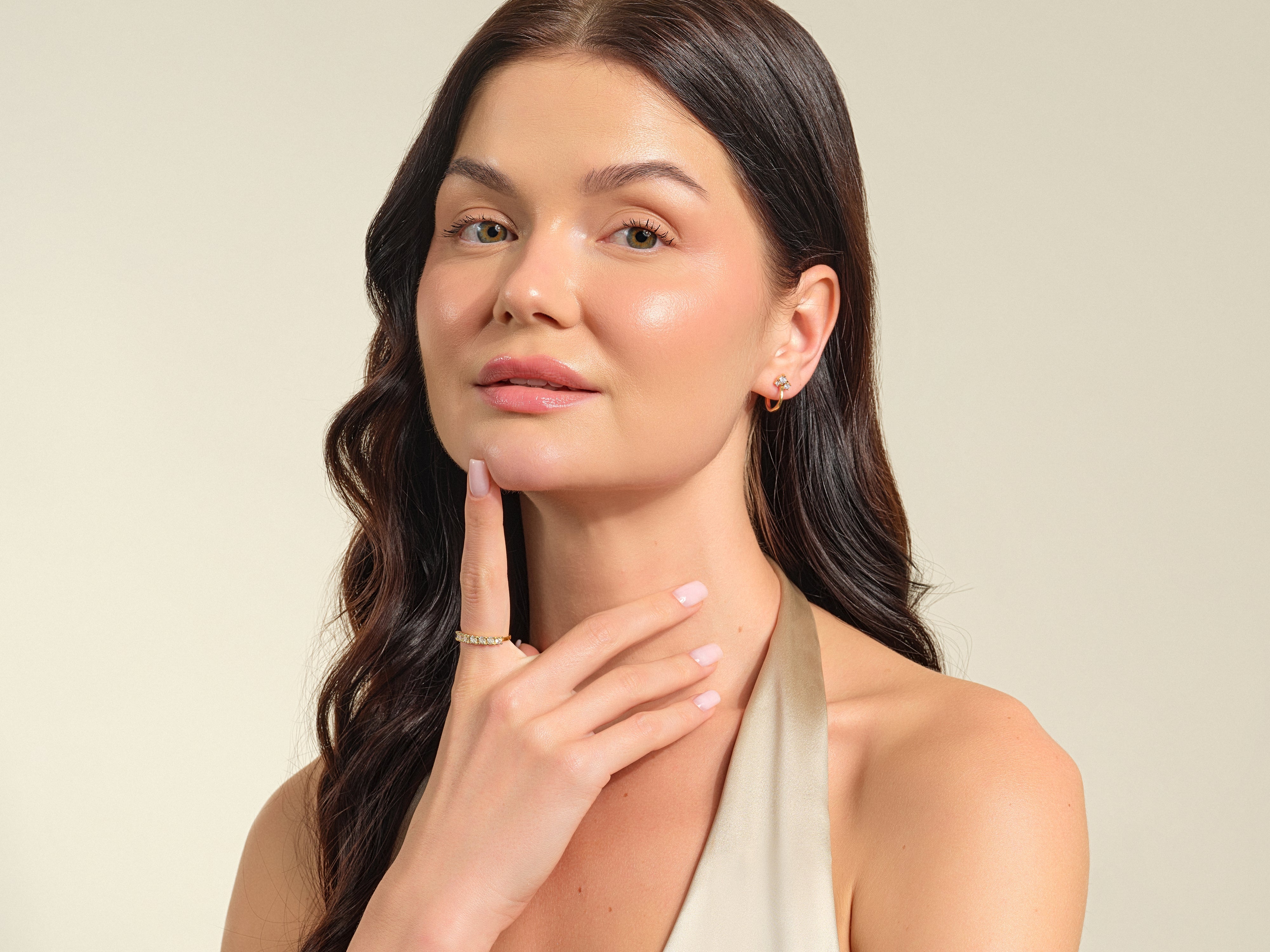 Woman wearing diamond earrings and ring, showcasing fine jewelry