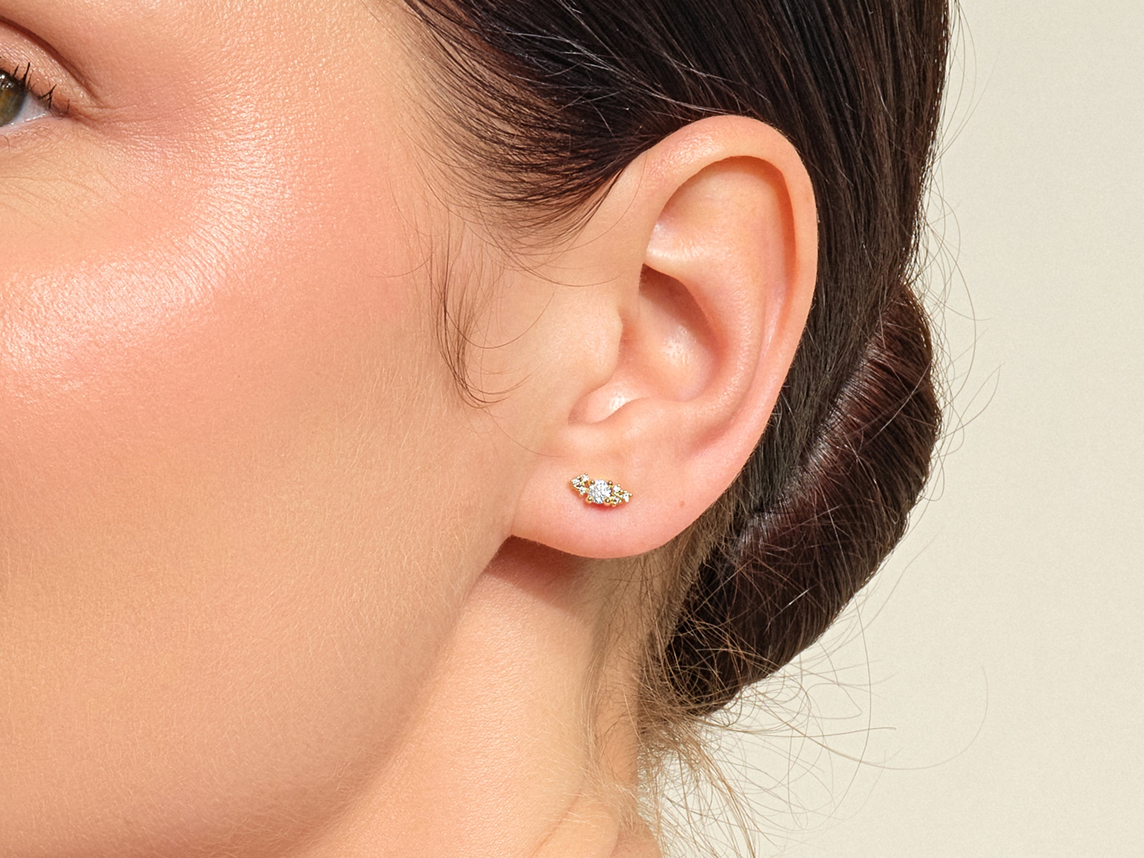 Gold diamond cluster stud earring on ear