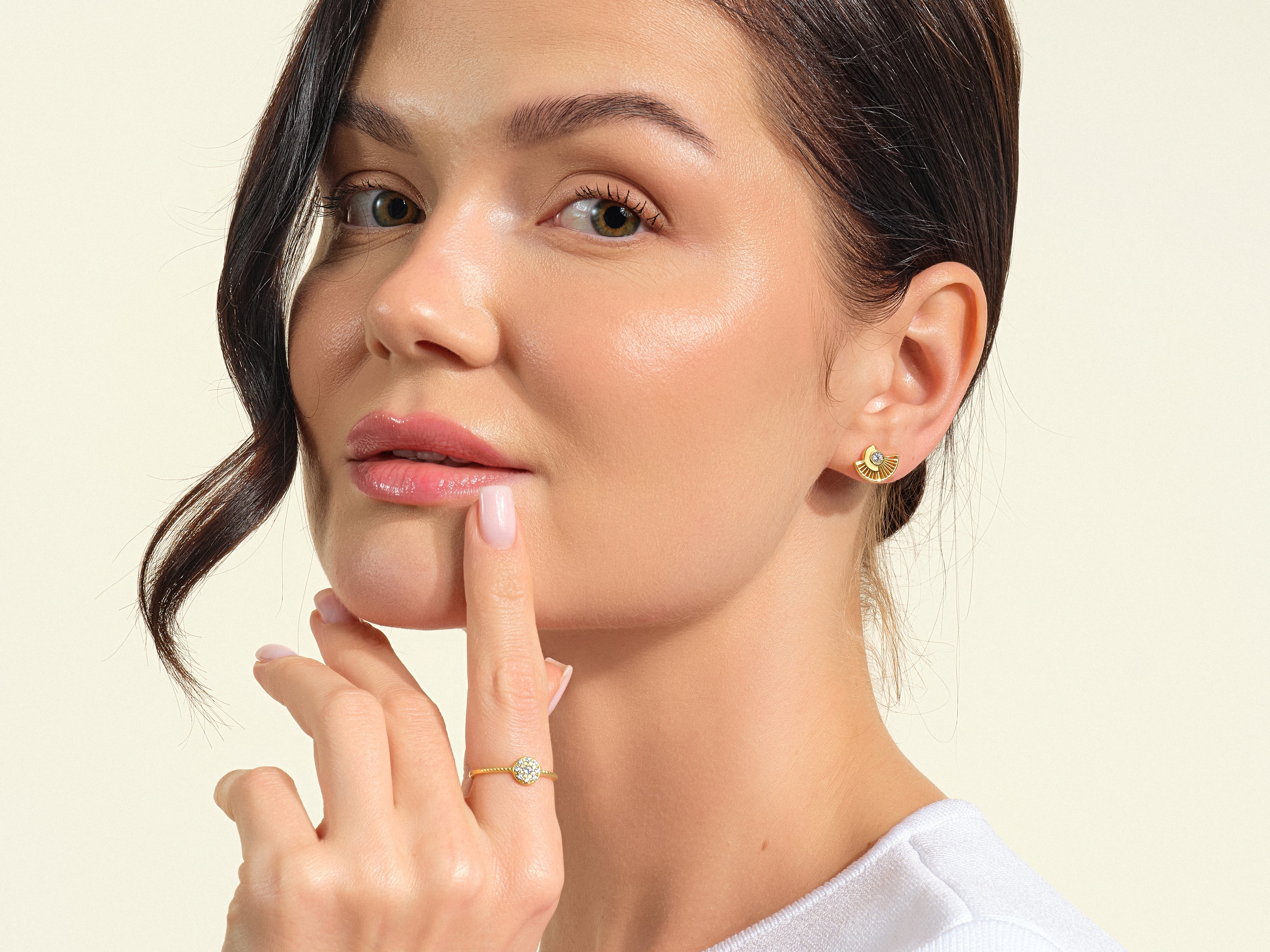 Woman wearing gold fan earrings and diamond ring