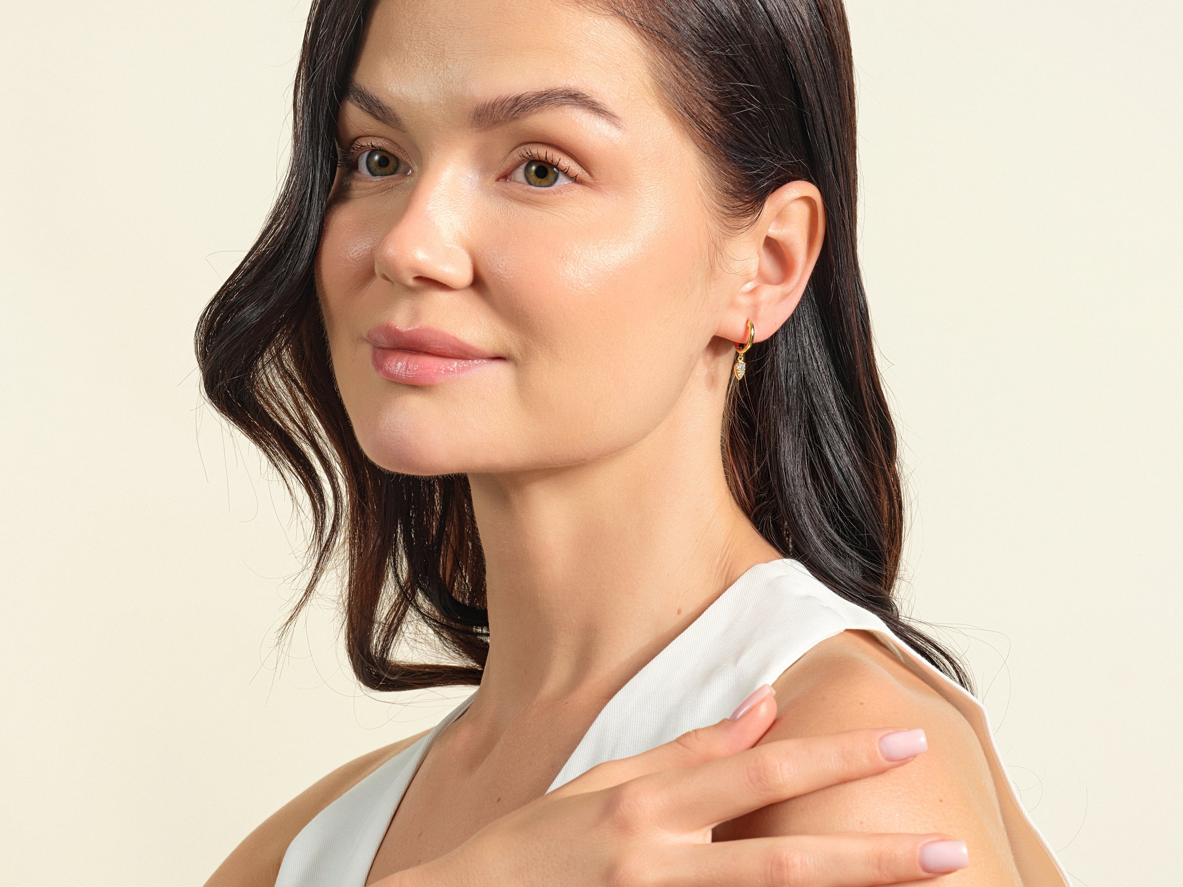 Elegant woman wearing delicate gold diamond earrings from jewelry collection