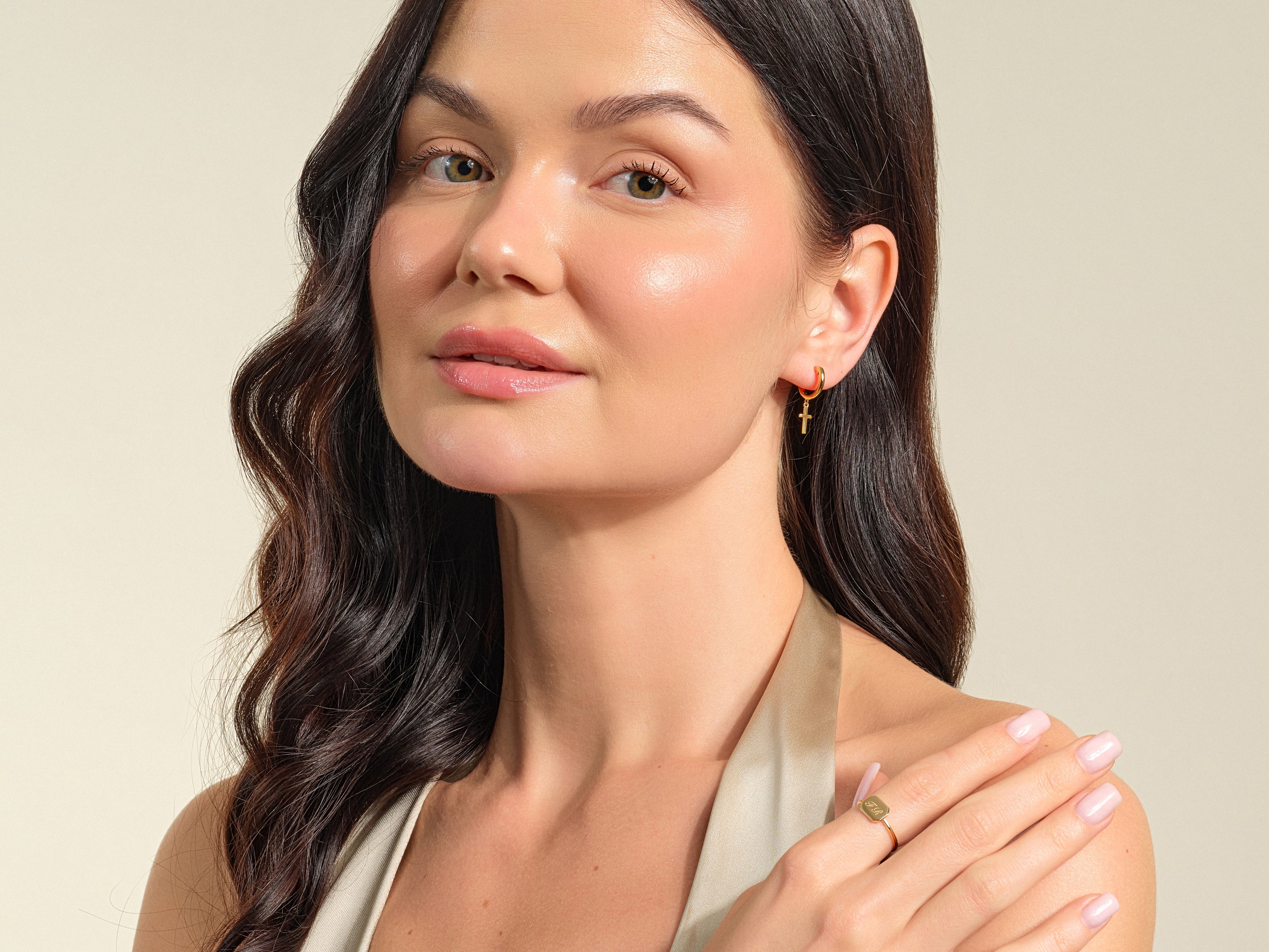 Gold cross hoop earring and initial ring on model