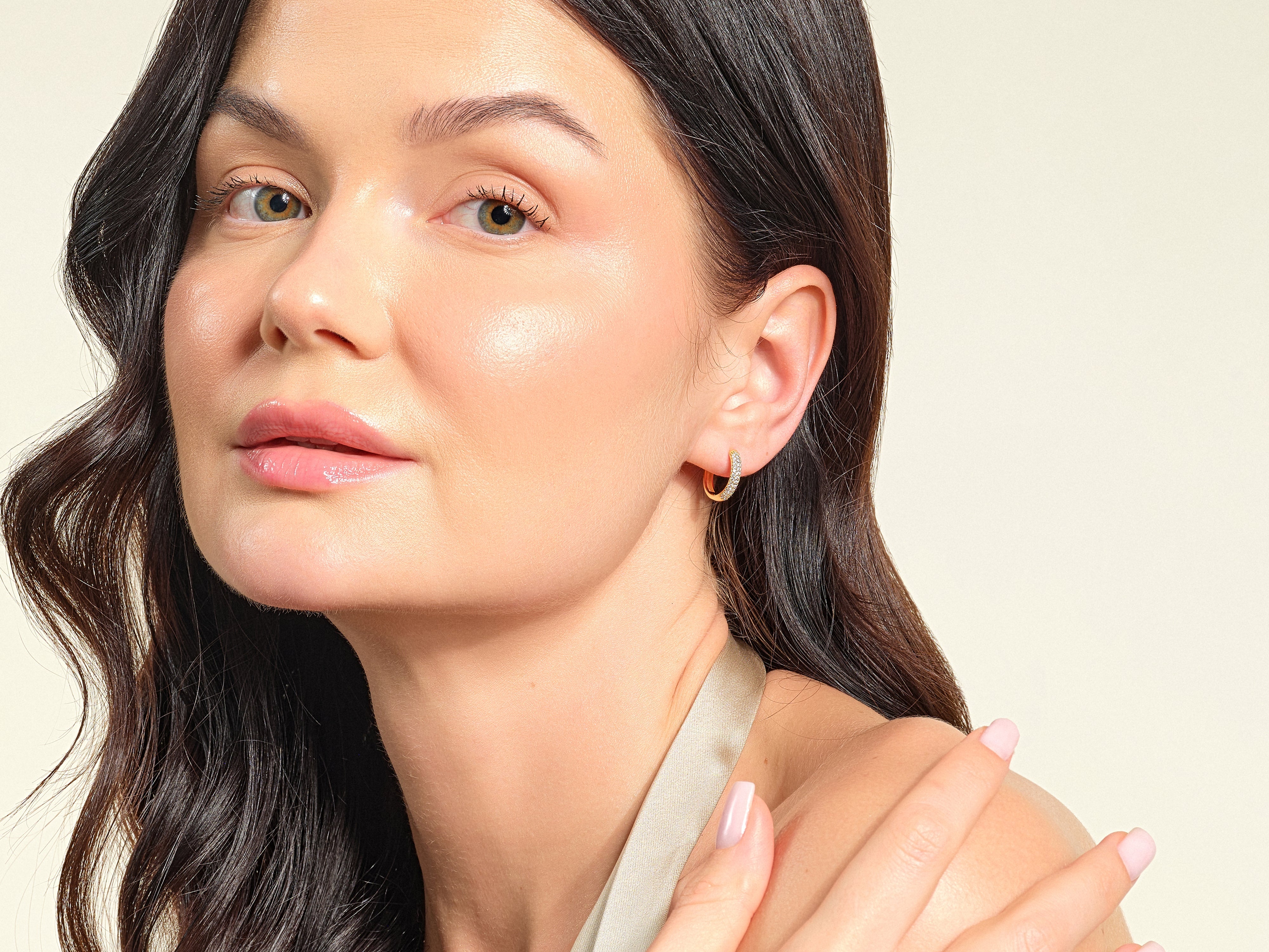 Woman wearing diamond hoop earrings, showcasing jewelry from a luxury brand