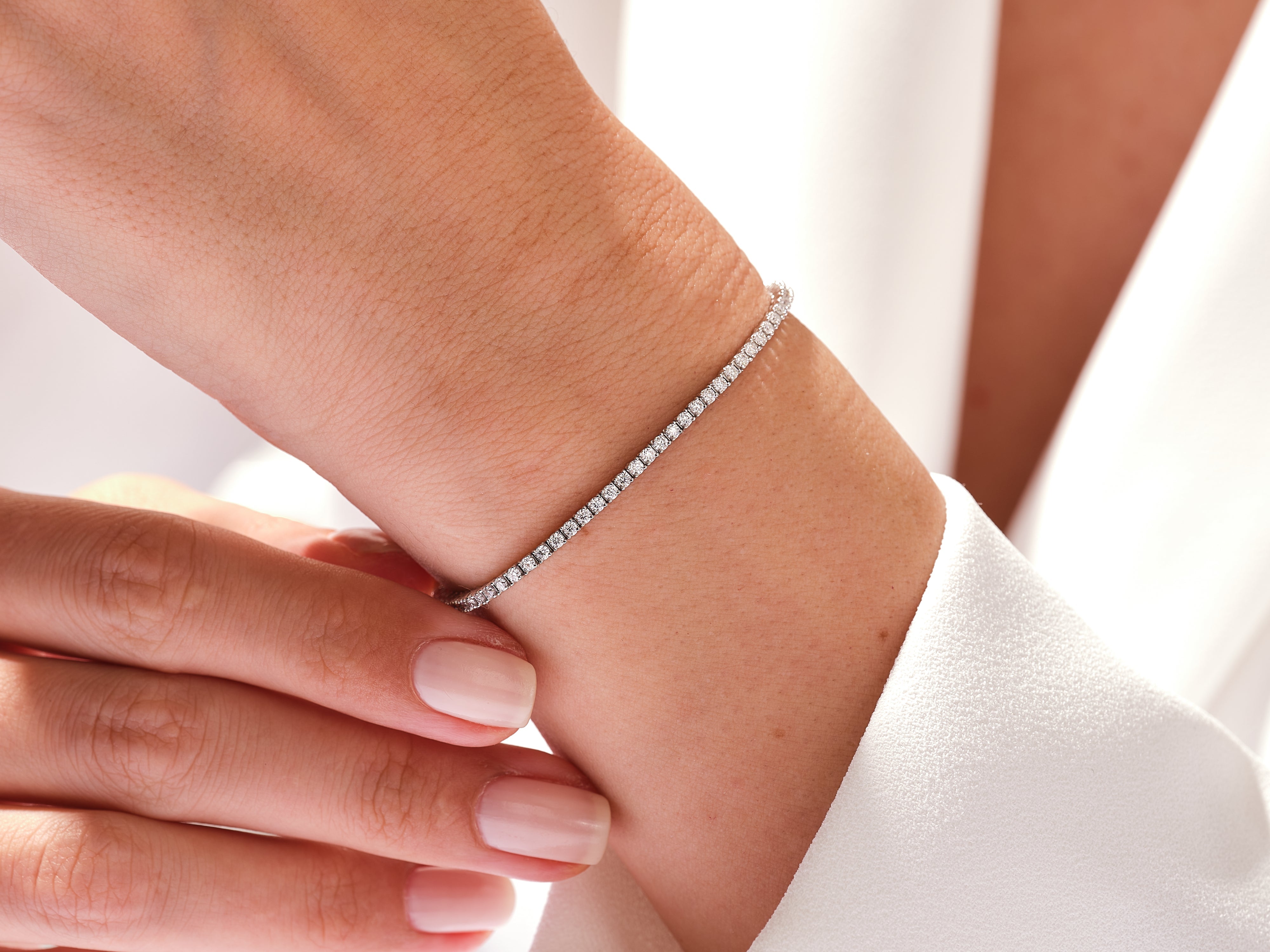 Diamond tennis bracelet on a woman's wrist, fine jewelry