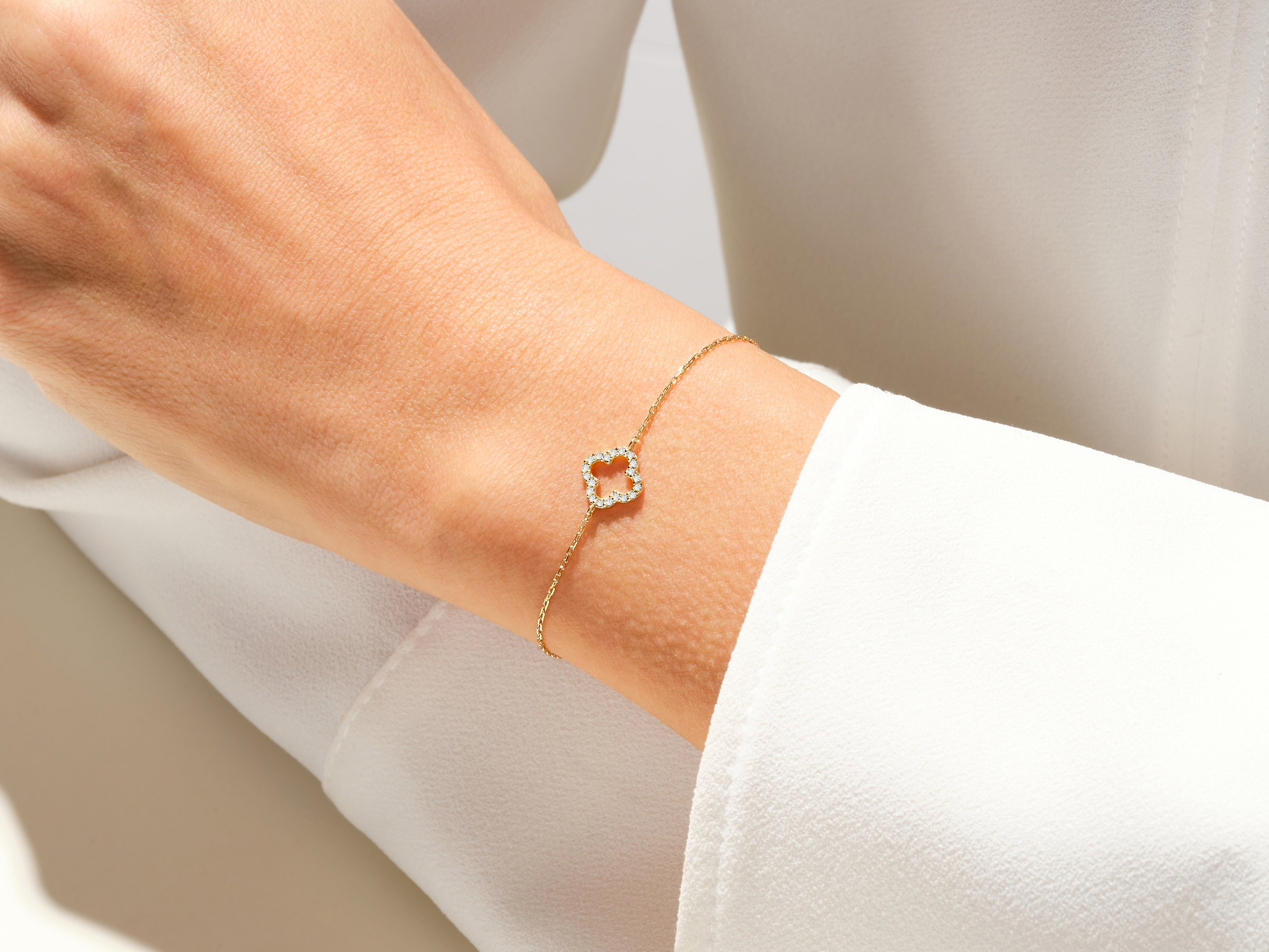 Gold diamond clover bracelet on a woman's wrist