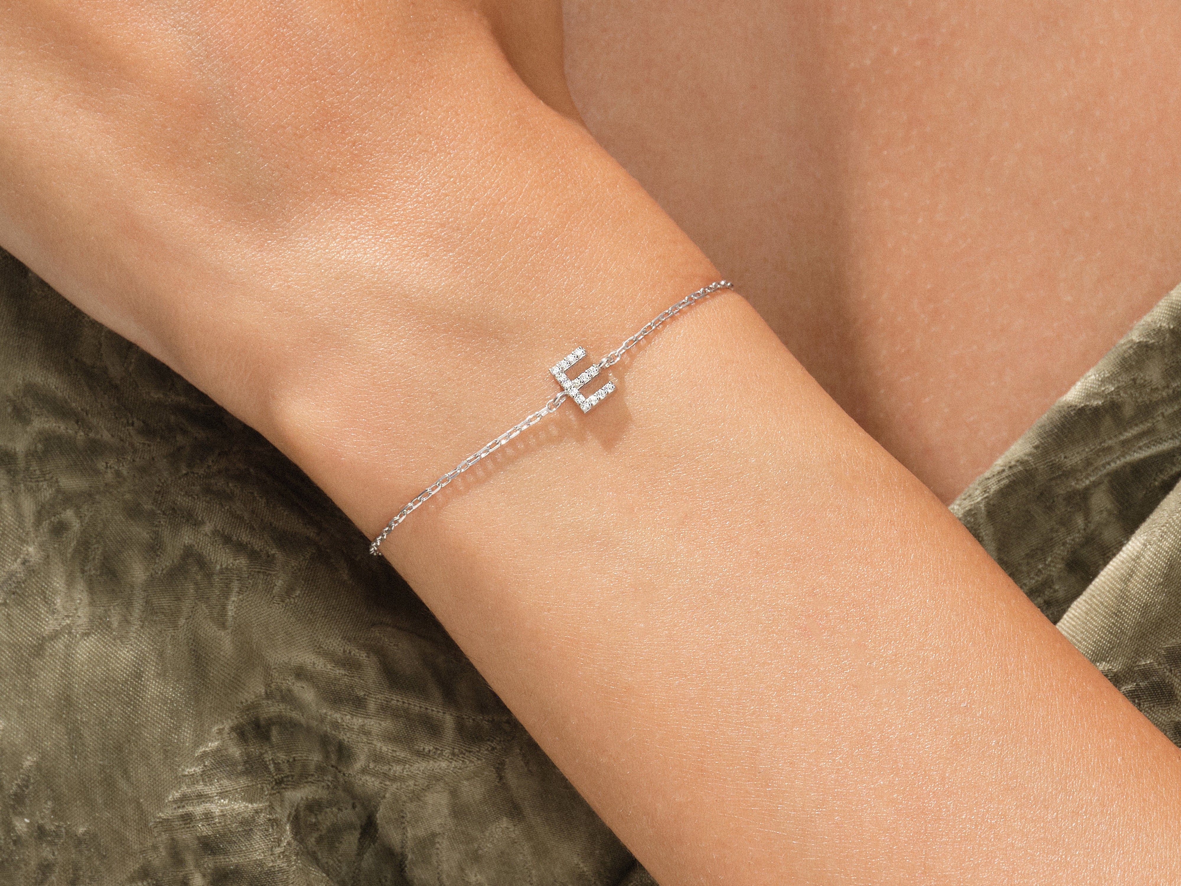 Diamond initial 'E' bracelet on a woman's wrist, fine jewelry