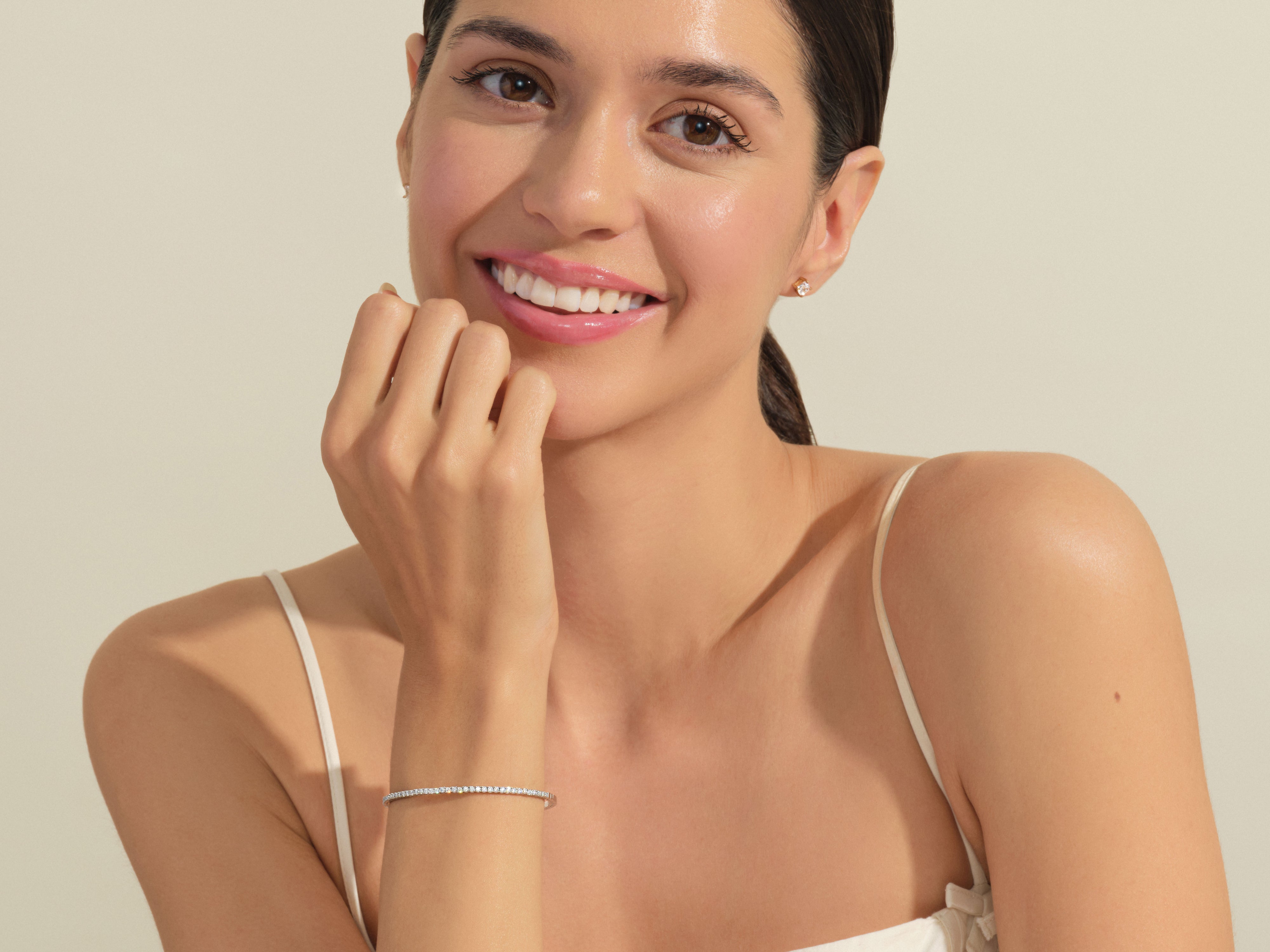 Diamond tennis bracelet on smiling woman, jewelry product photography