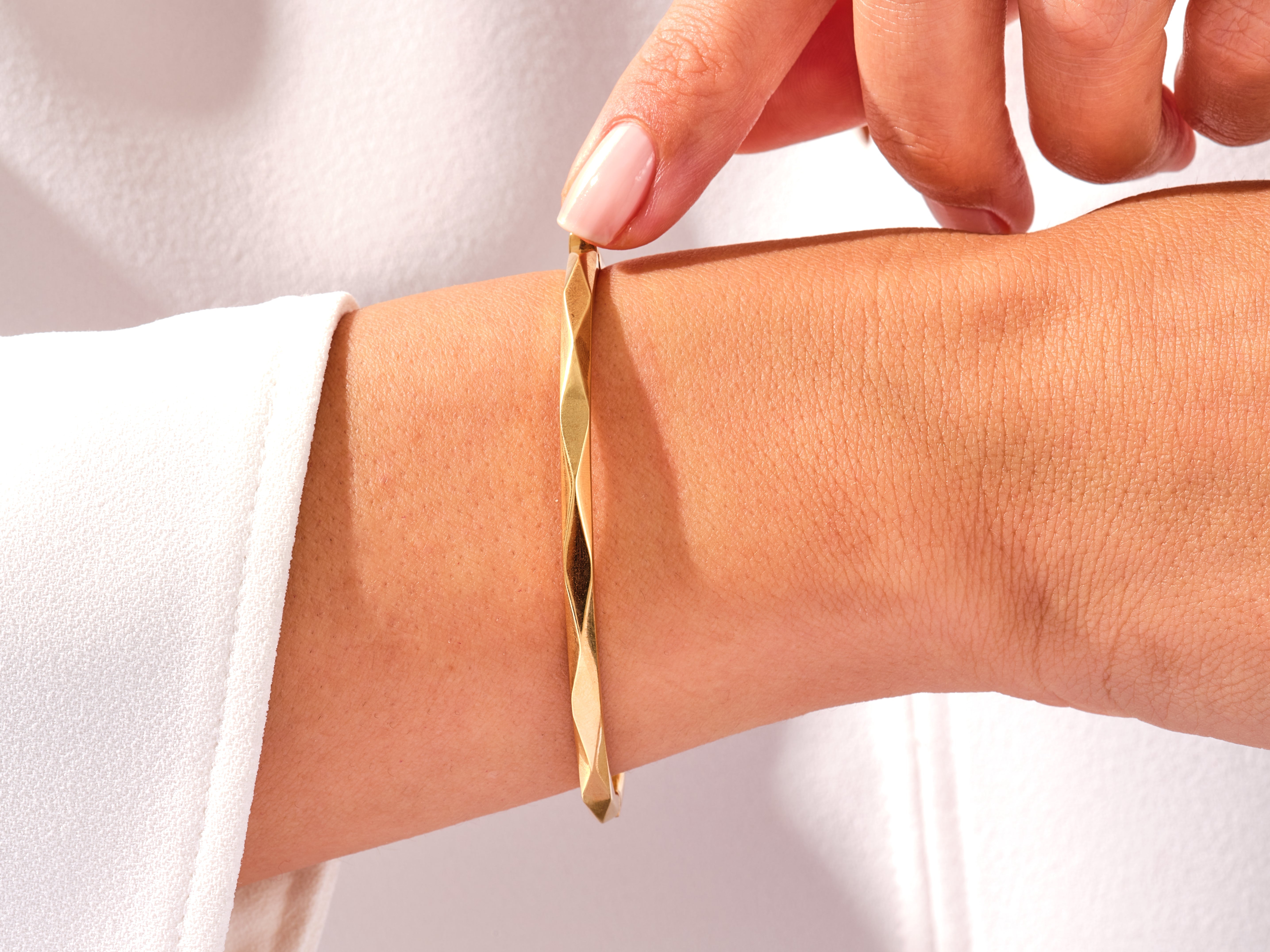 Gold geometric bangle on wrist, jewelry photography