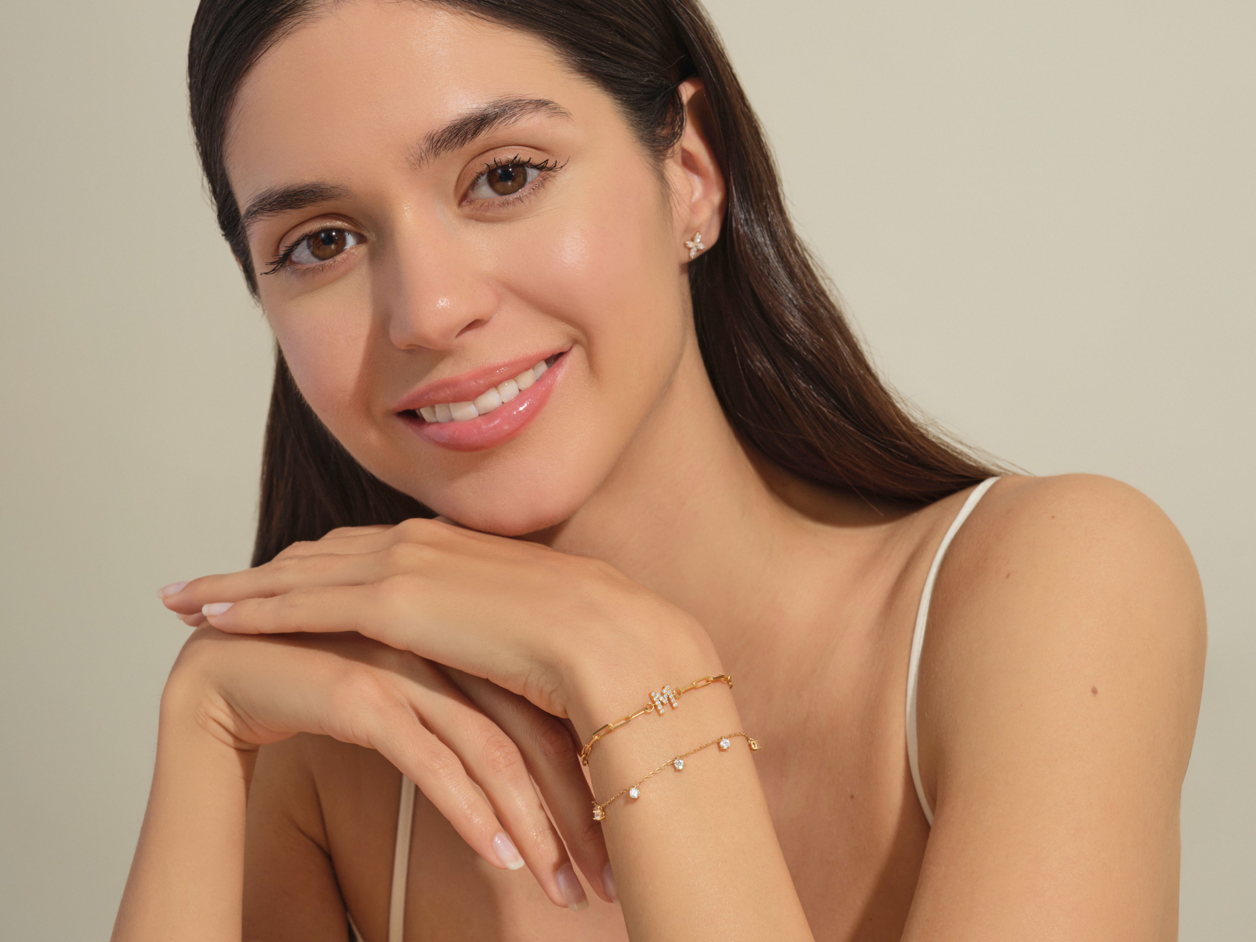 Model wearing delicate gold bracelets and earrings from jewelry collection