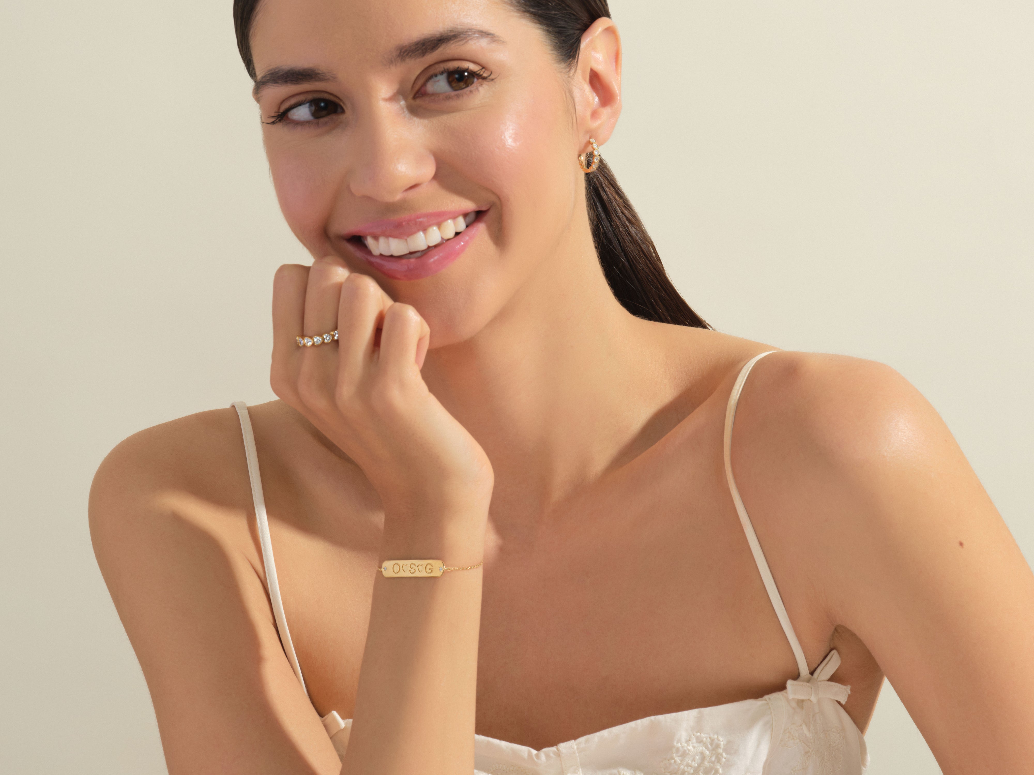 Gold personalized bracelet and diamond ring on smiling woman