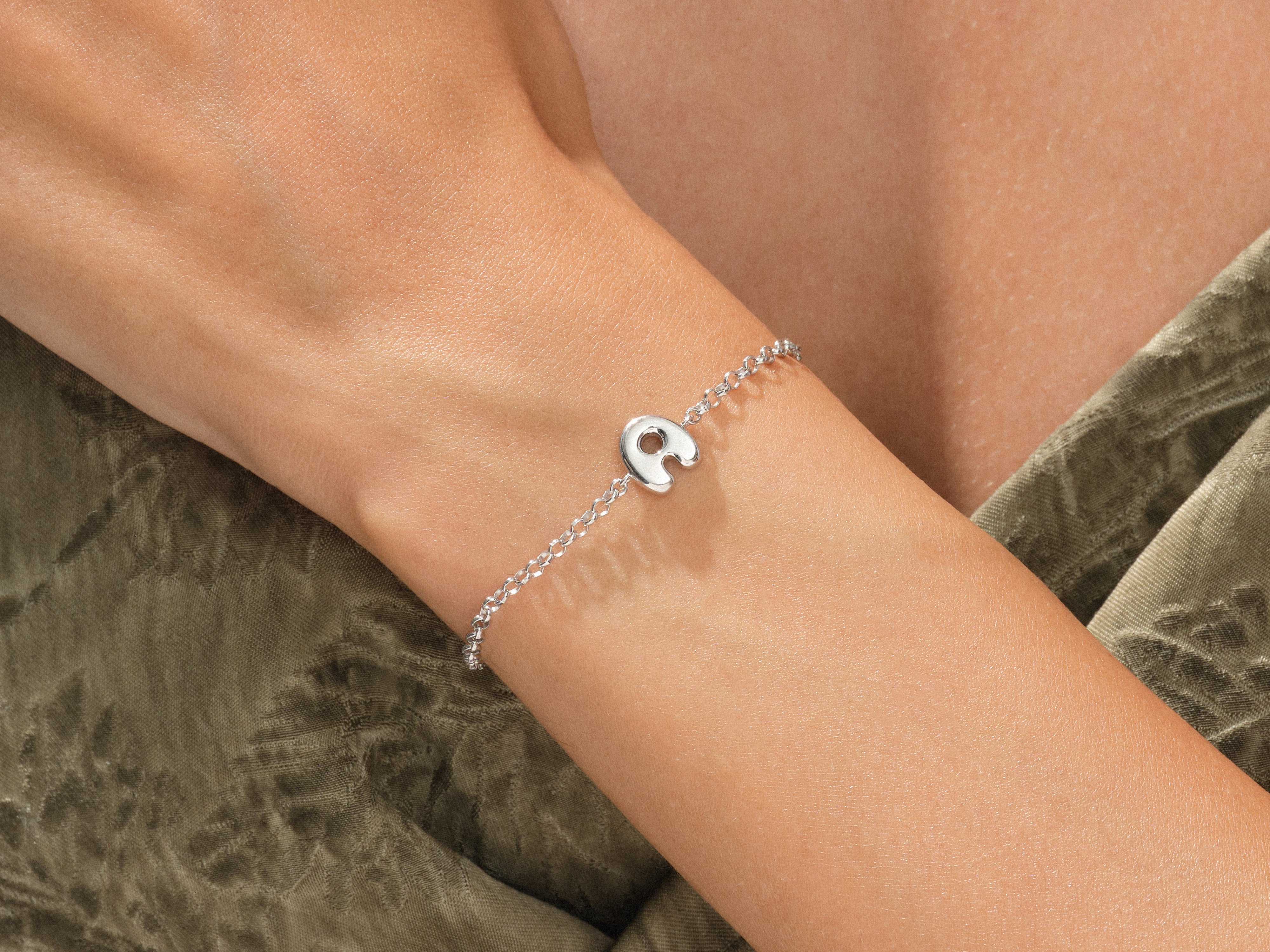 Silver initial bracelet on a woman's wrist, jewelry