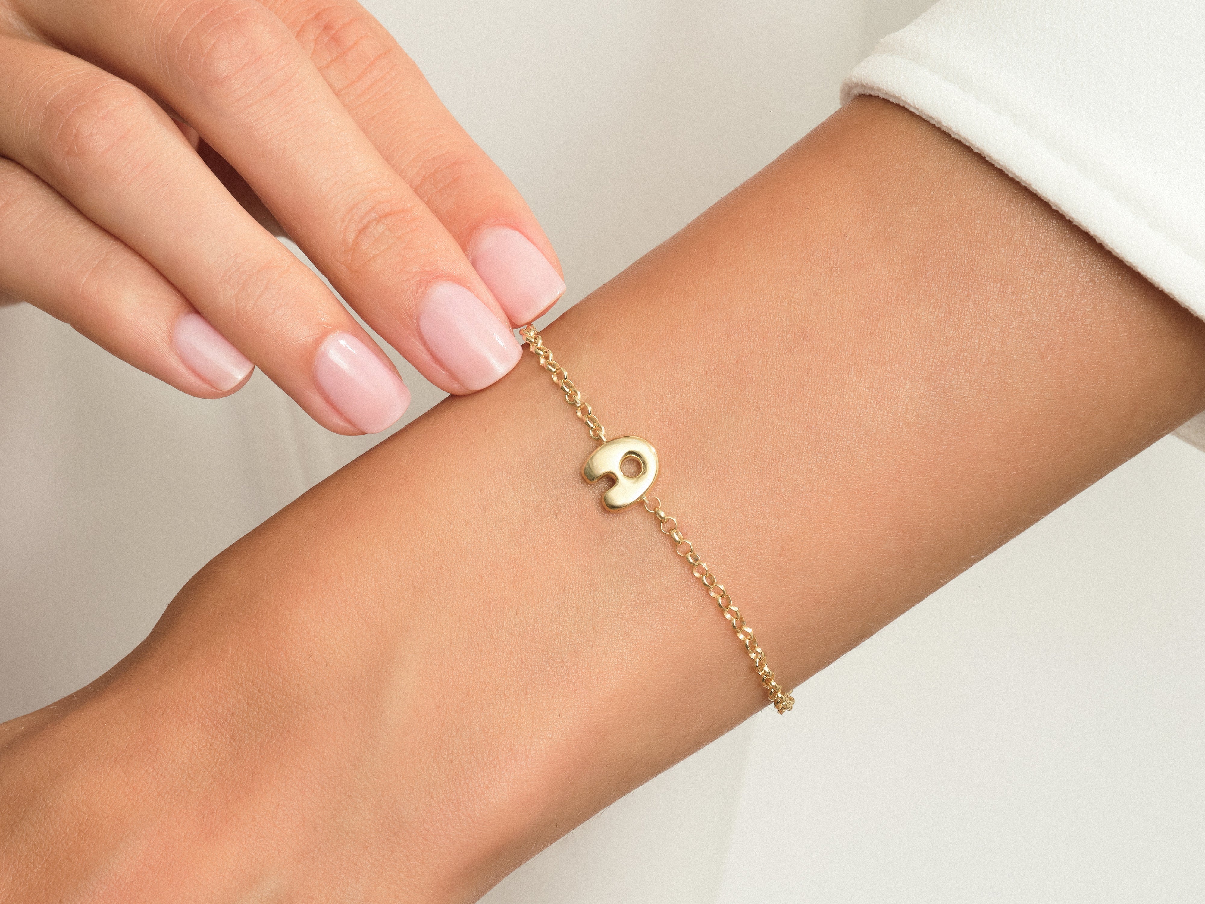Gold elephant charm bracelet on a woman's wrist