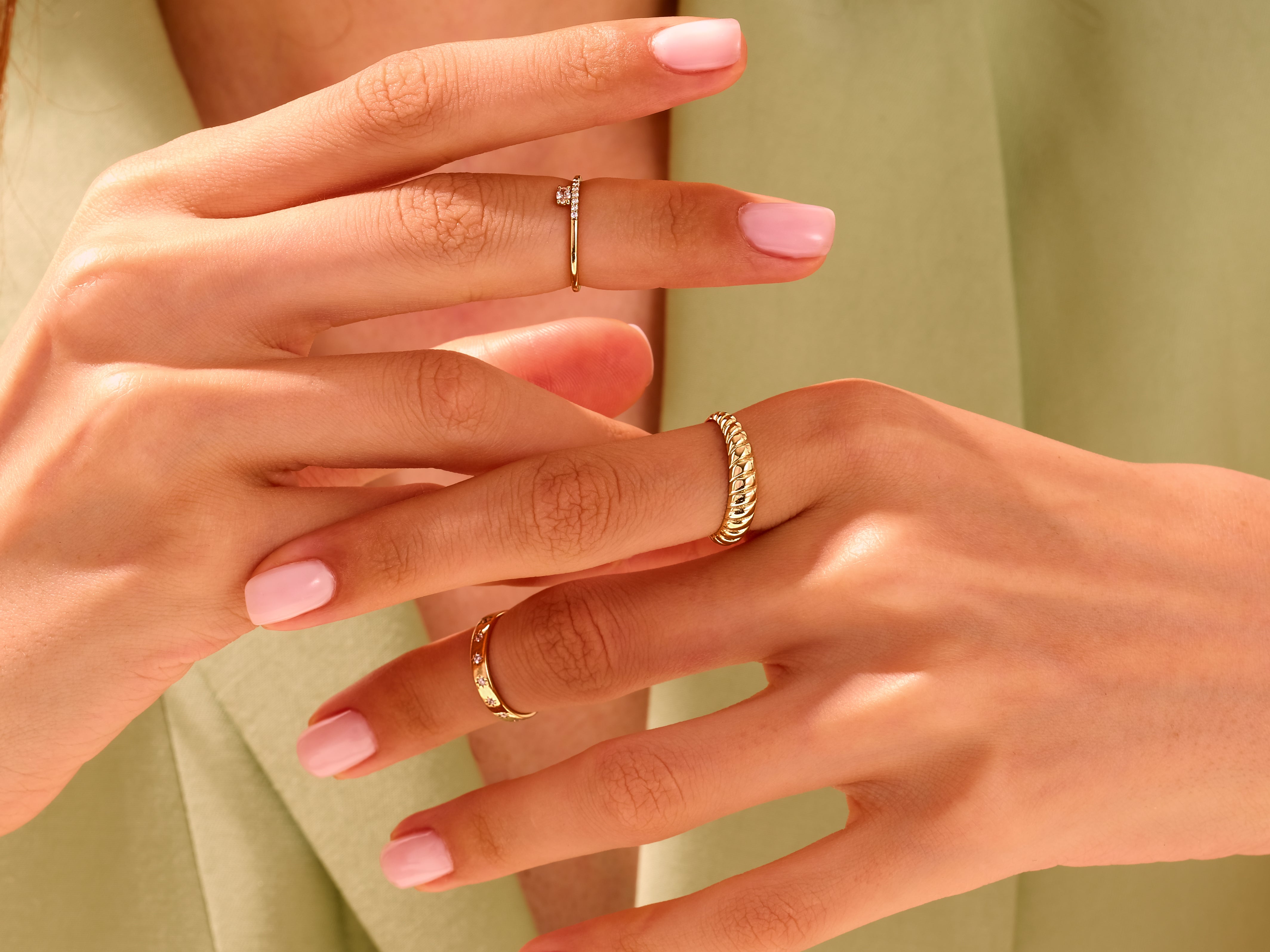 Elegant gold rings on manicured hands, showcasing fine jewelry designs