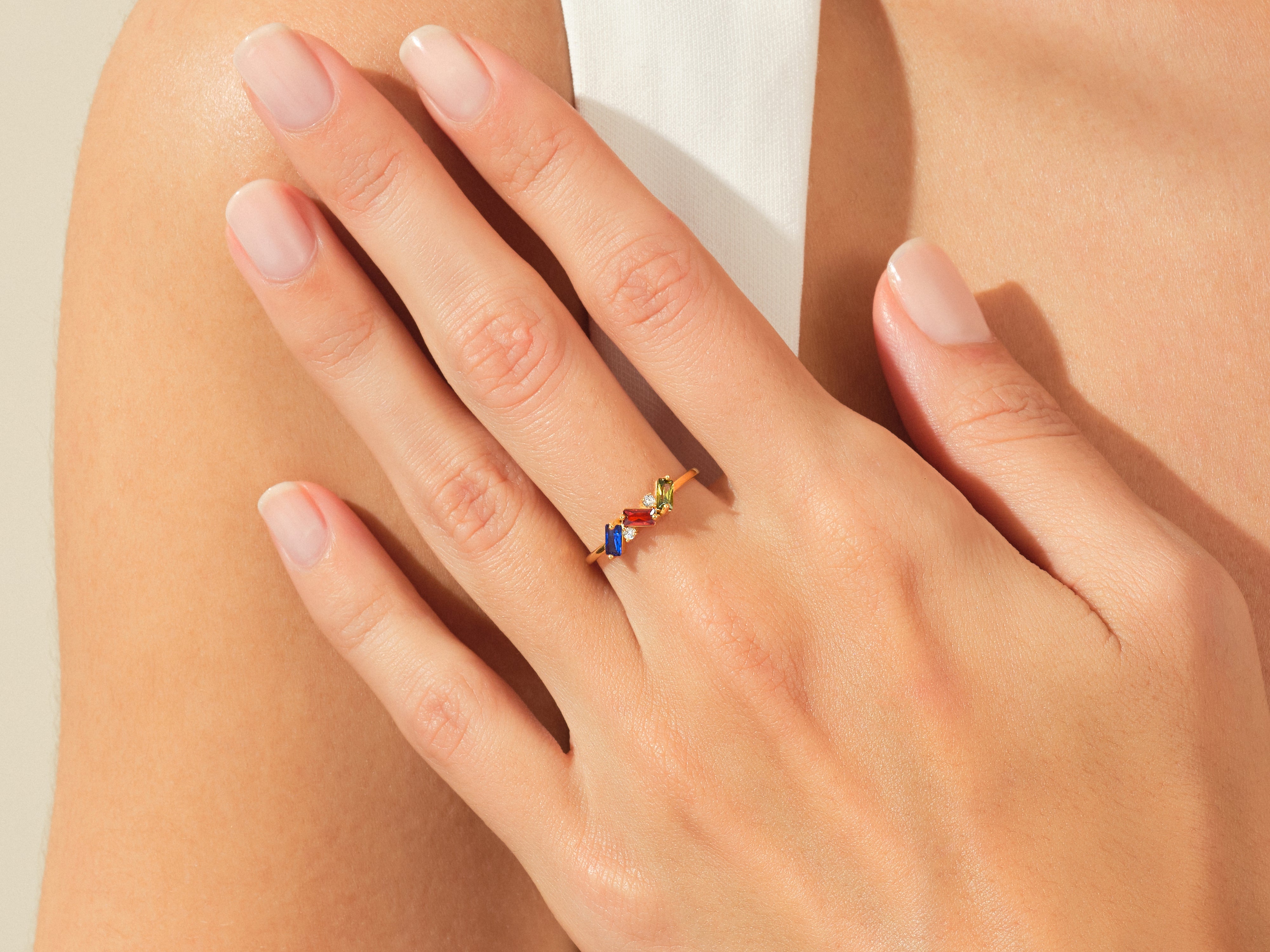 Gold ring with colorful gemstones on a woman's hand