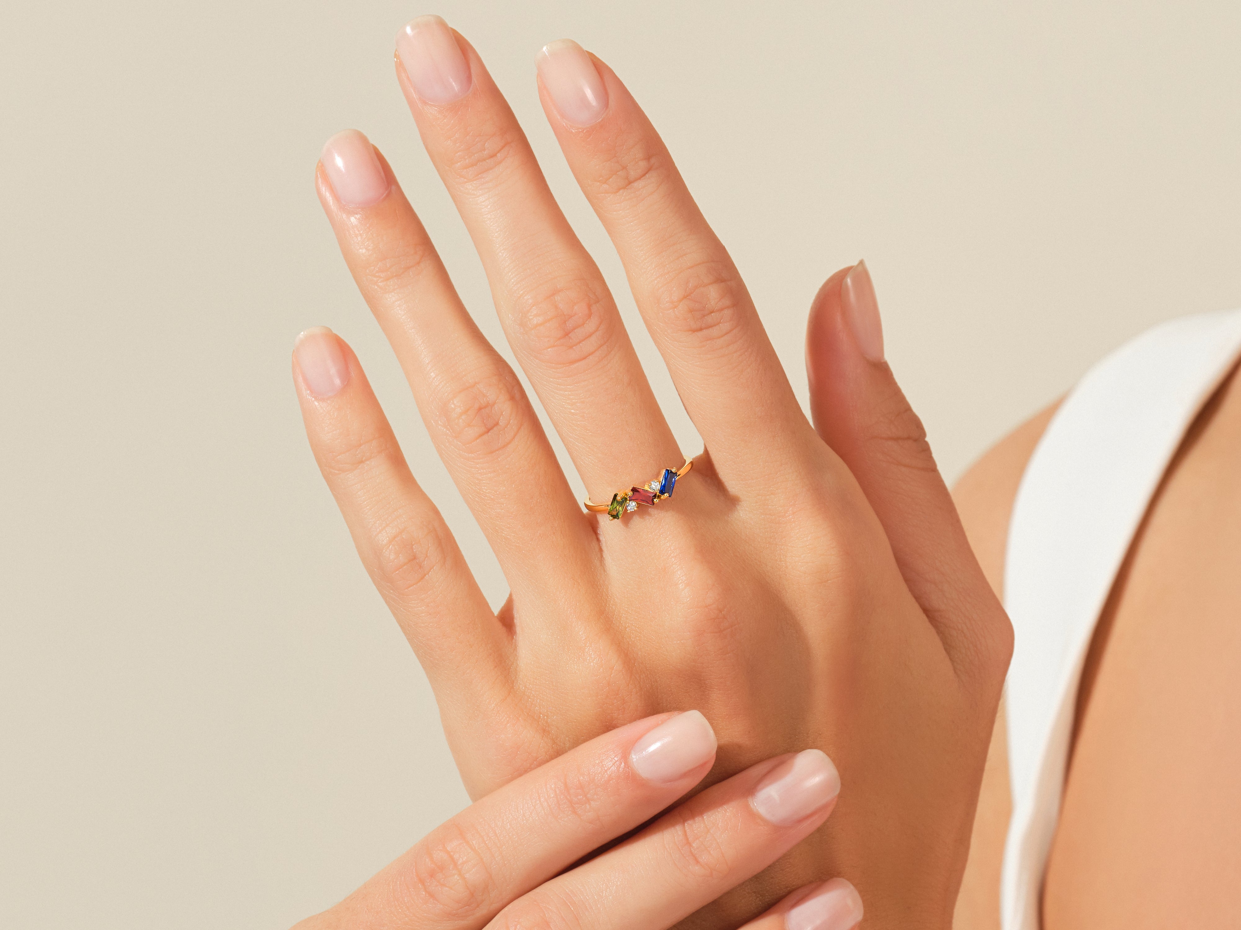 Gold ring with colorful gemstones on a woman's hand