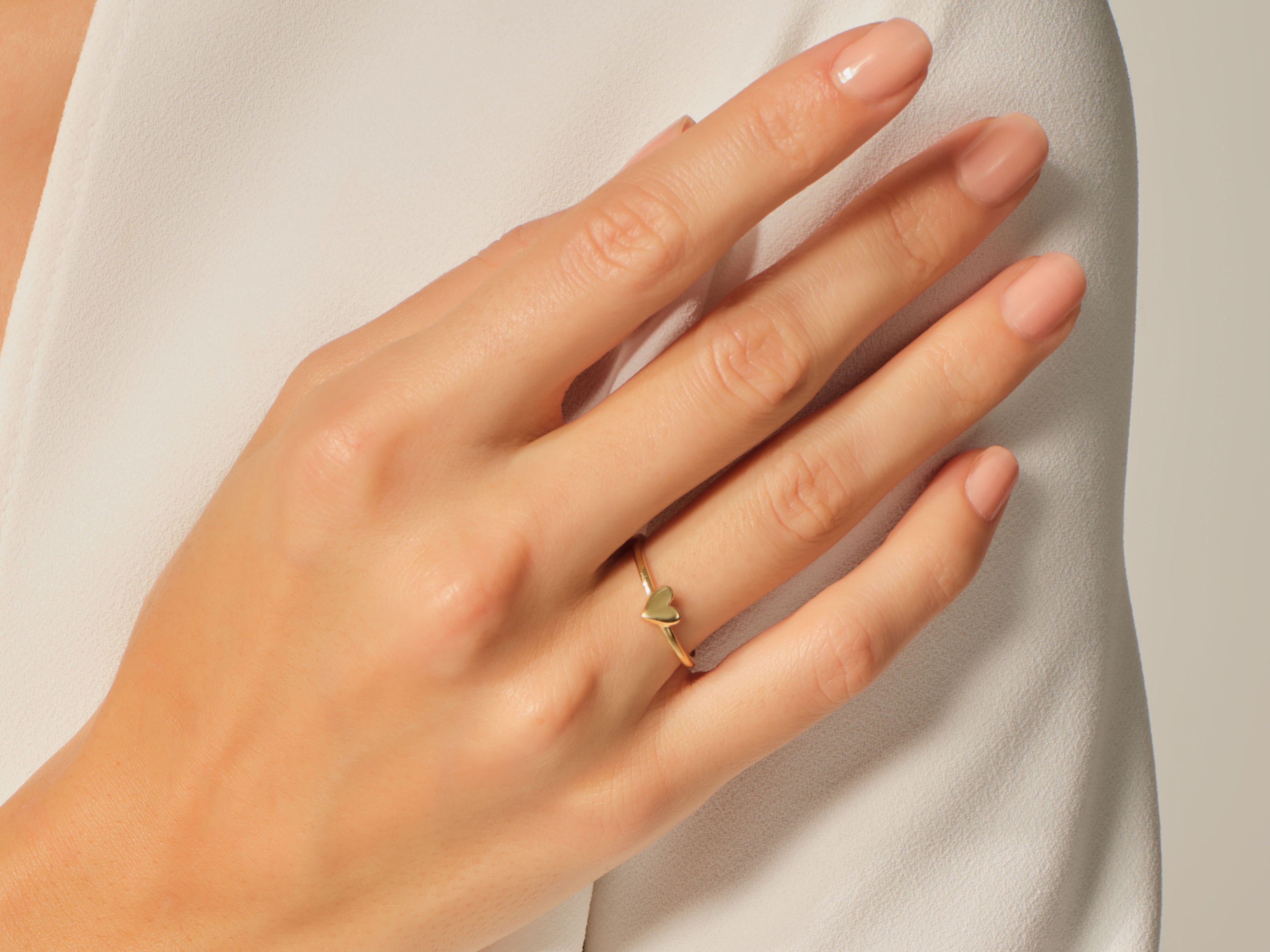 Gold heart ring on a woman's finger, jewelry product