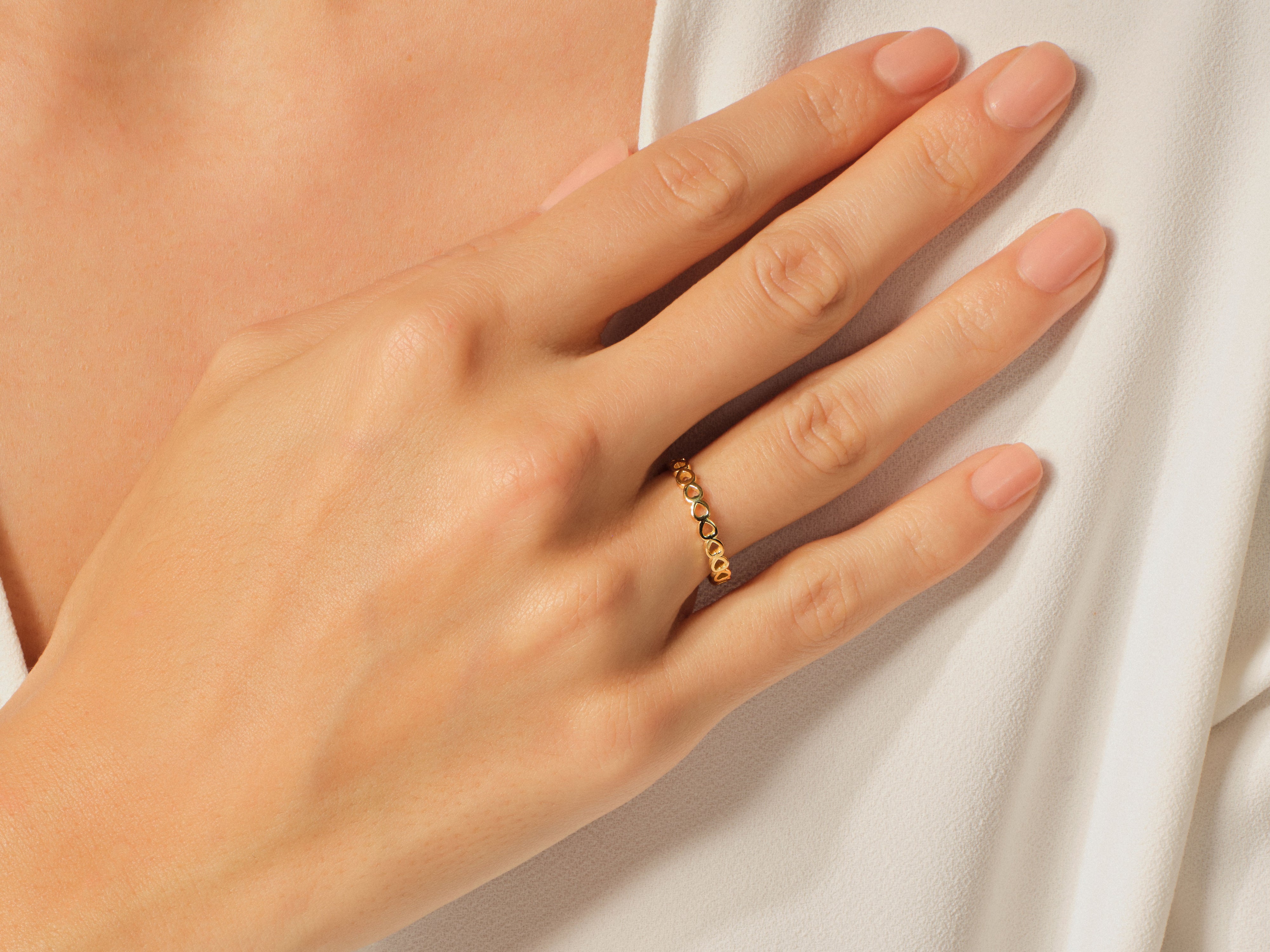 Delicate gold heart ring on a woman's finger, jewelry