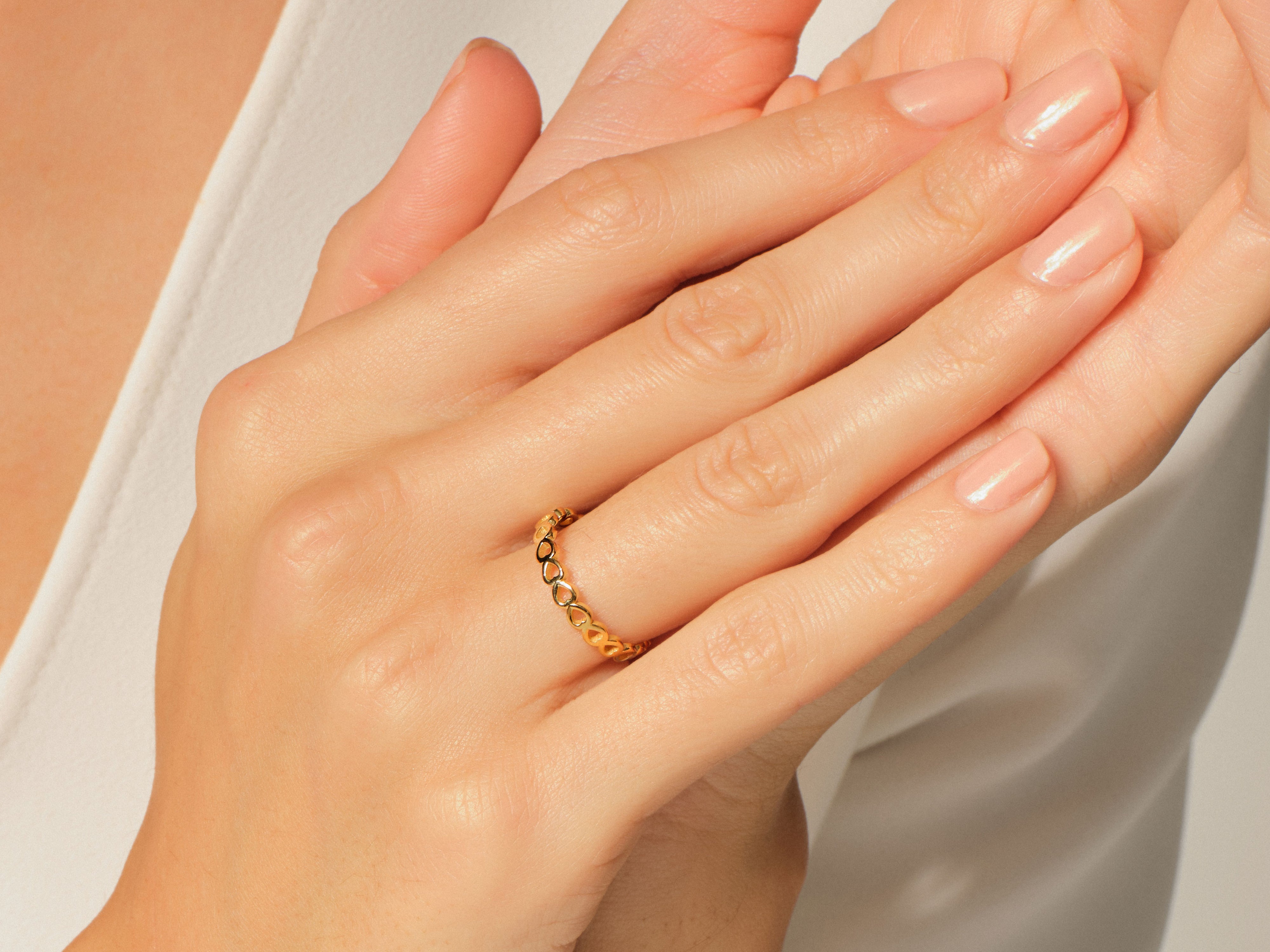 Gold heart ring on a woman's finger, jewelry photography