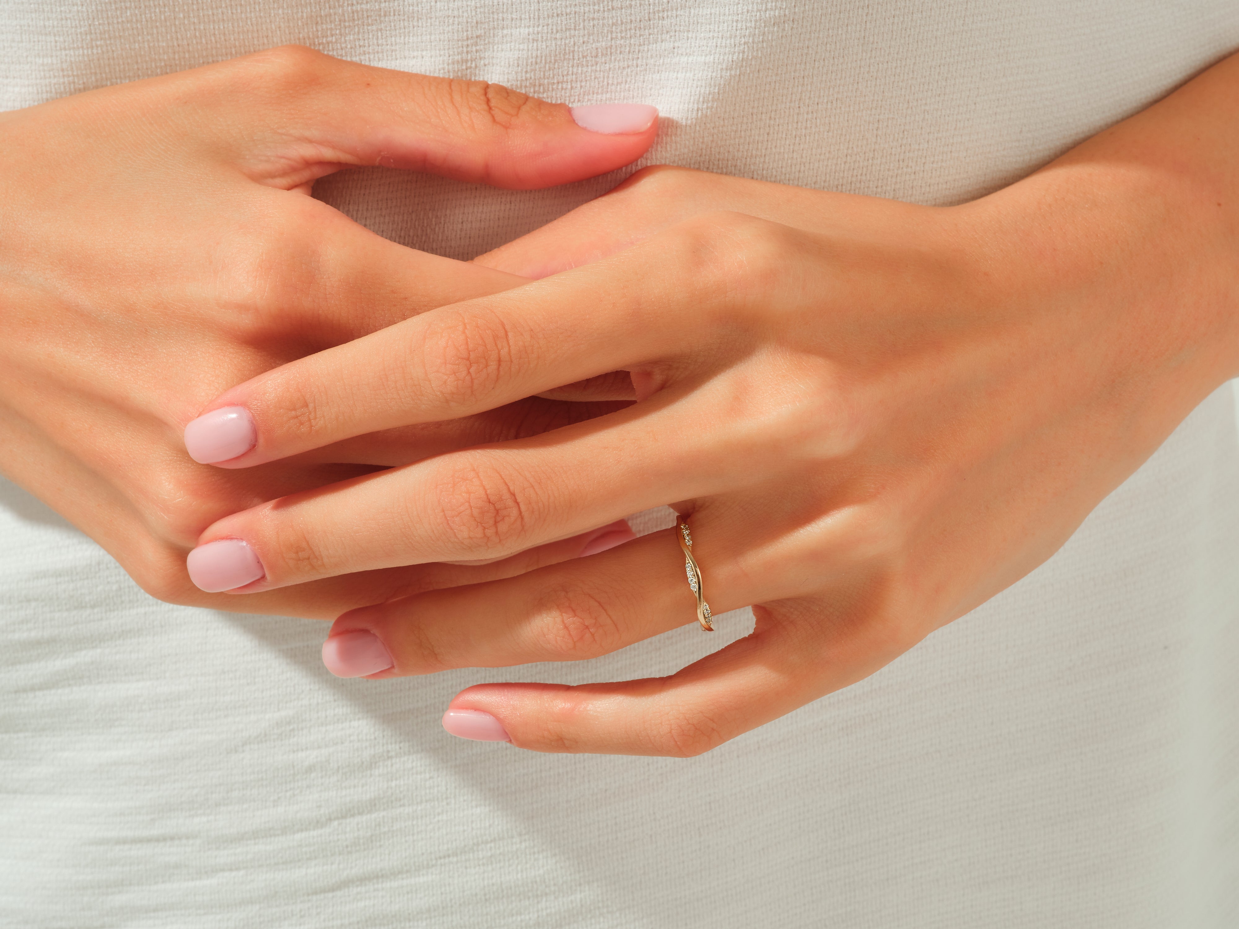 Diamond twisted band ring on a woman's finger, jewelry