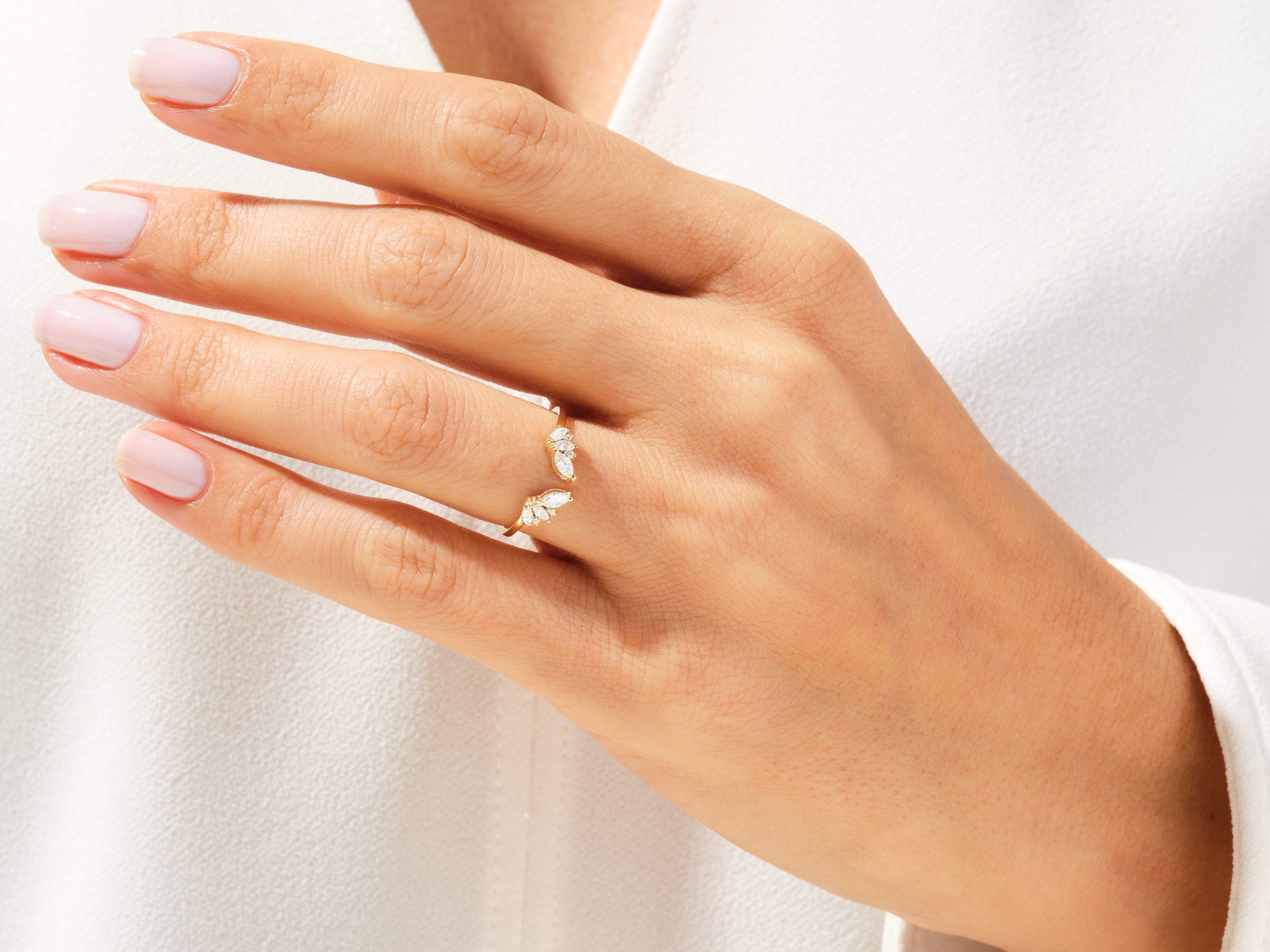 Gold diamond ring with marquise-cut stones on a woman's hand
