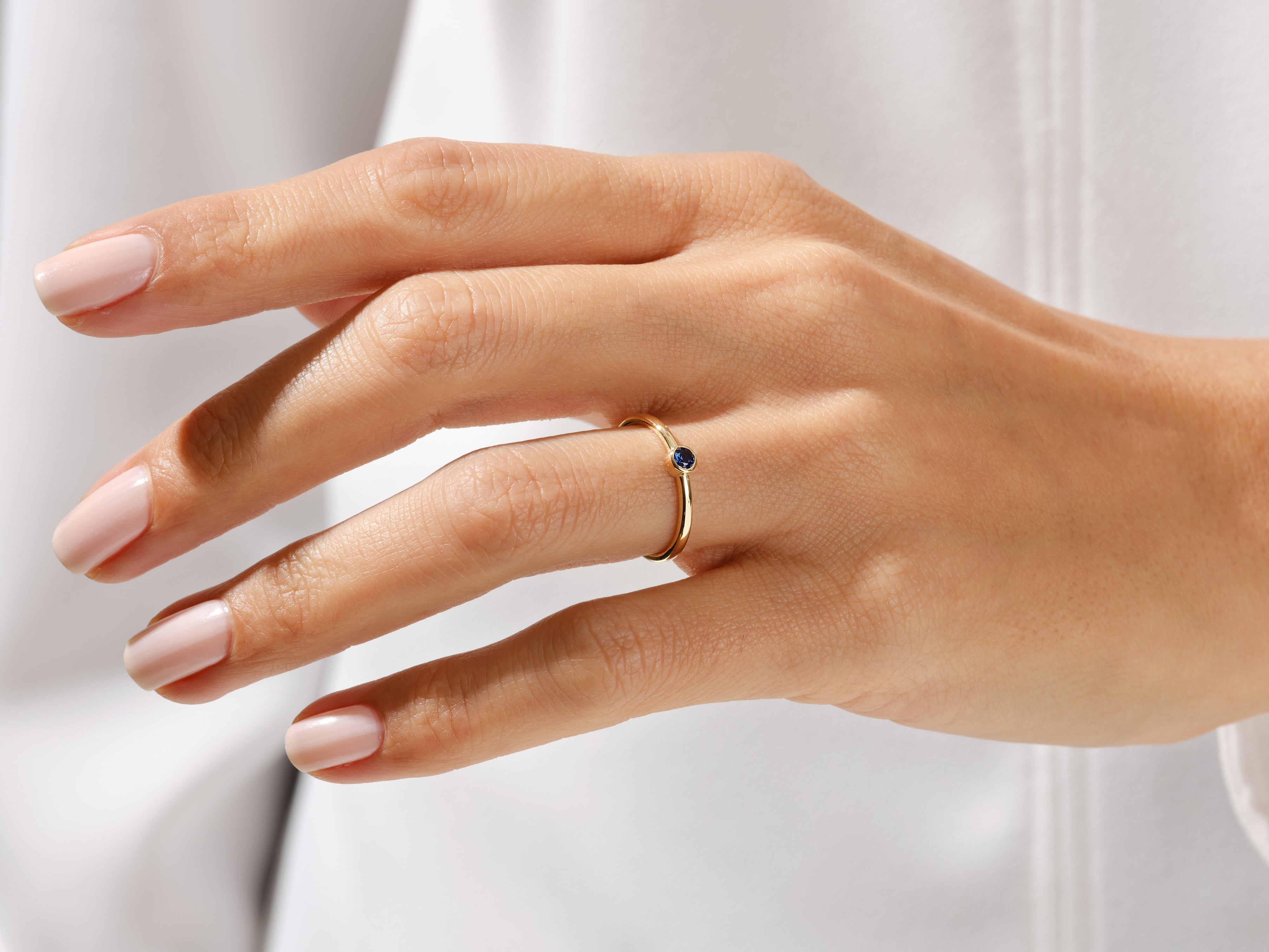 Gold ring with sapphire gemstone on a woman's hand