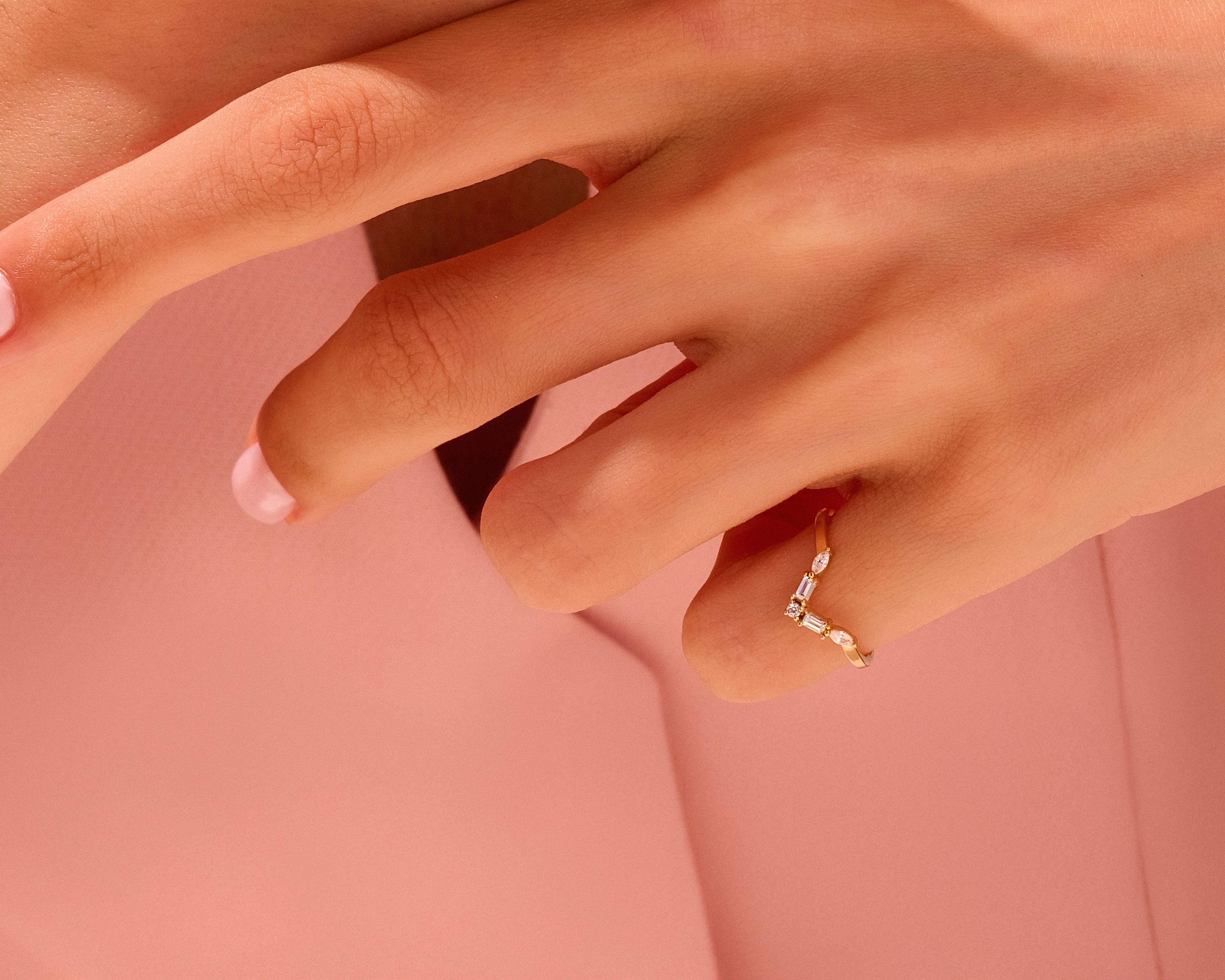 Gold chevron ring with diamonds on a hand