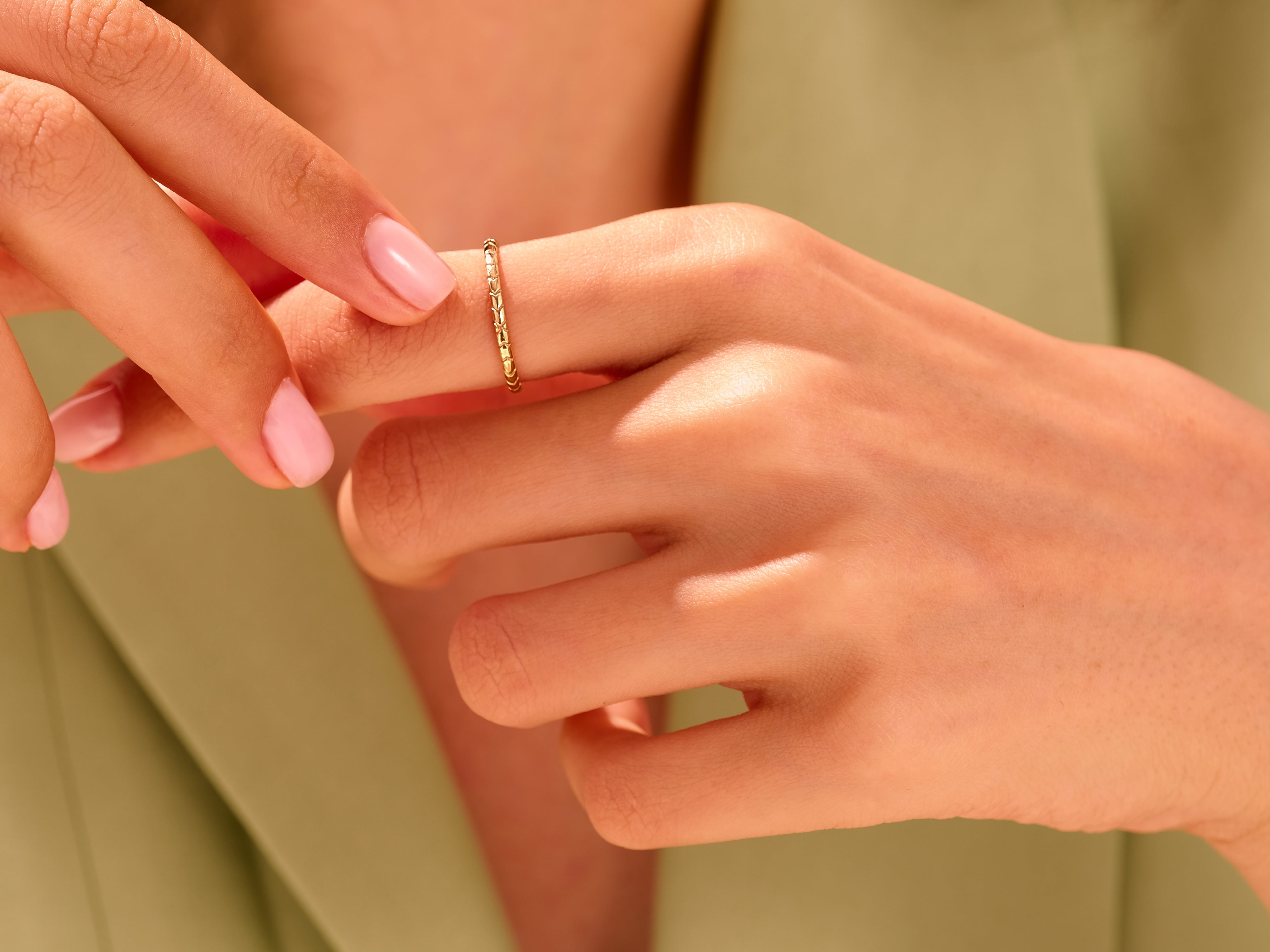 Delicate gold ring on a woman's finger, jewelry photography