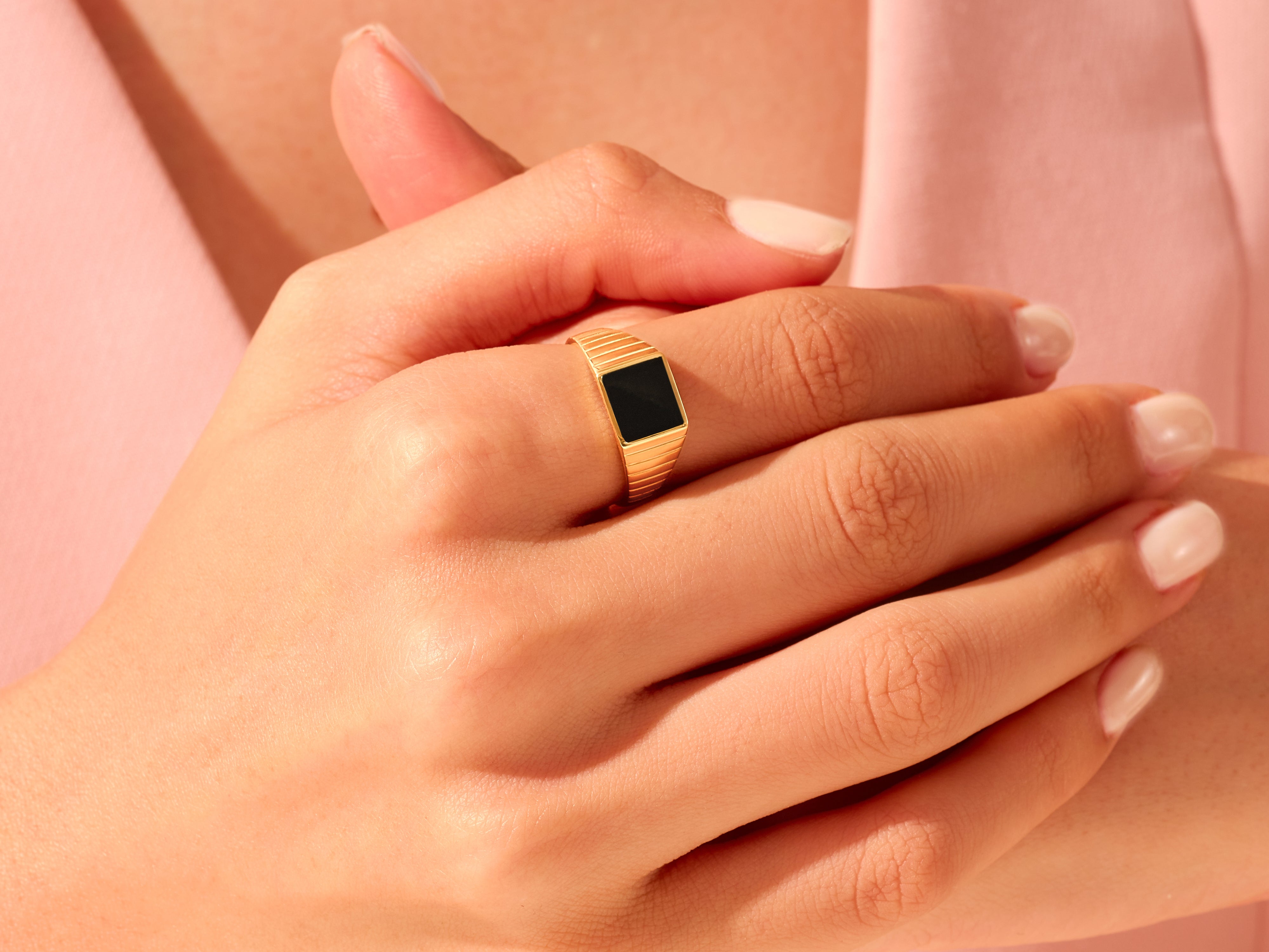 Gold ring with black stone on hand