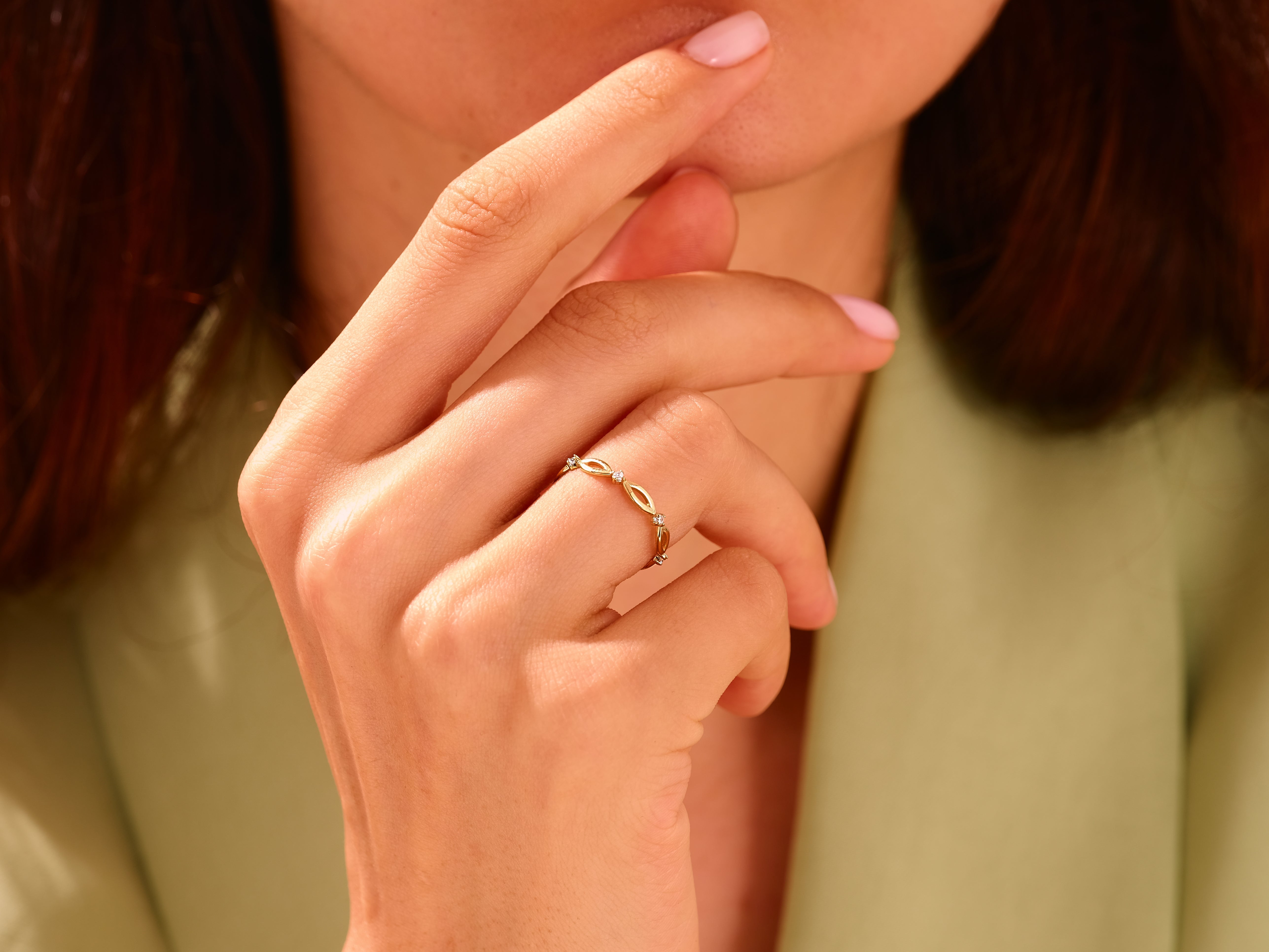 Delicate gold ring with diamonds on a woman's finger