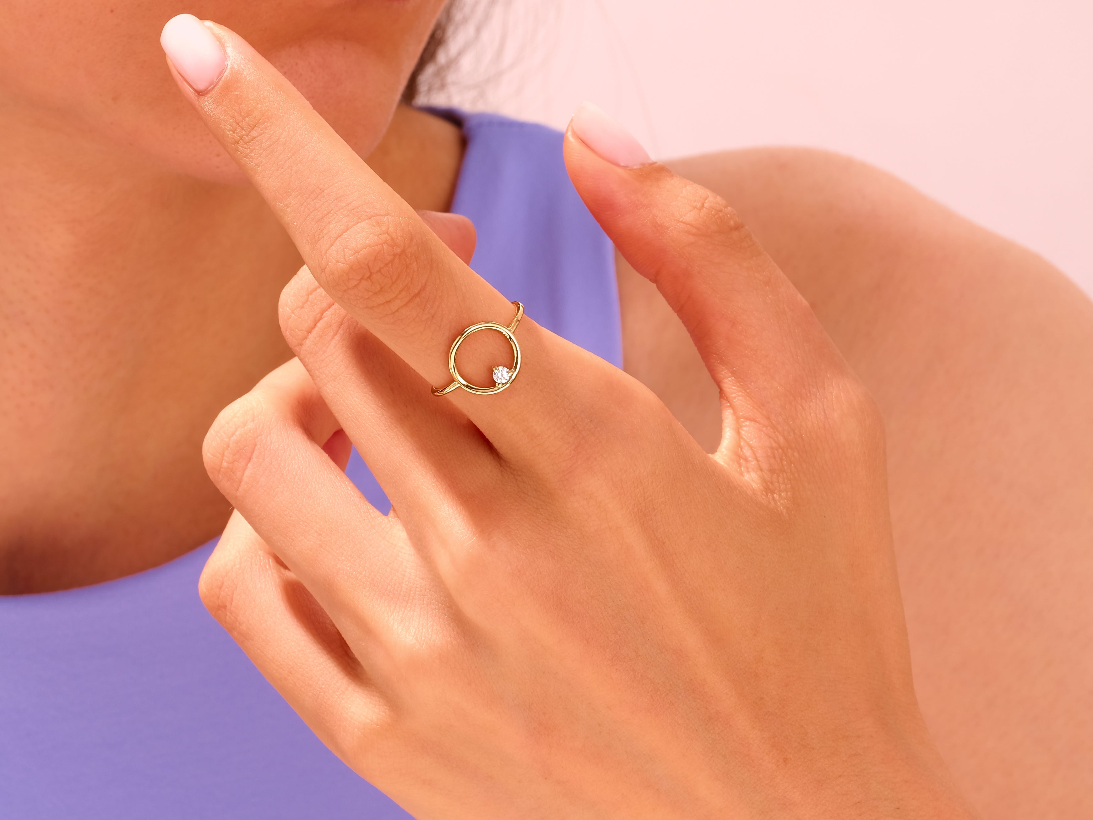 Gold circle ring with diamond accent on finger