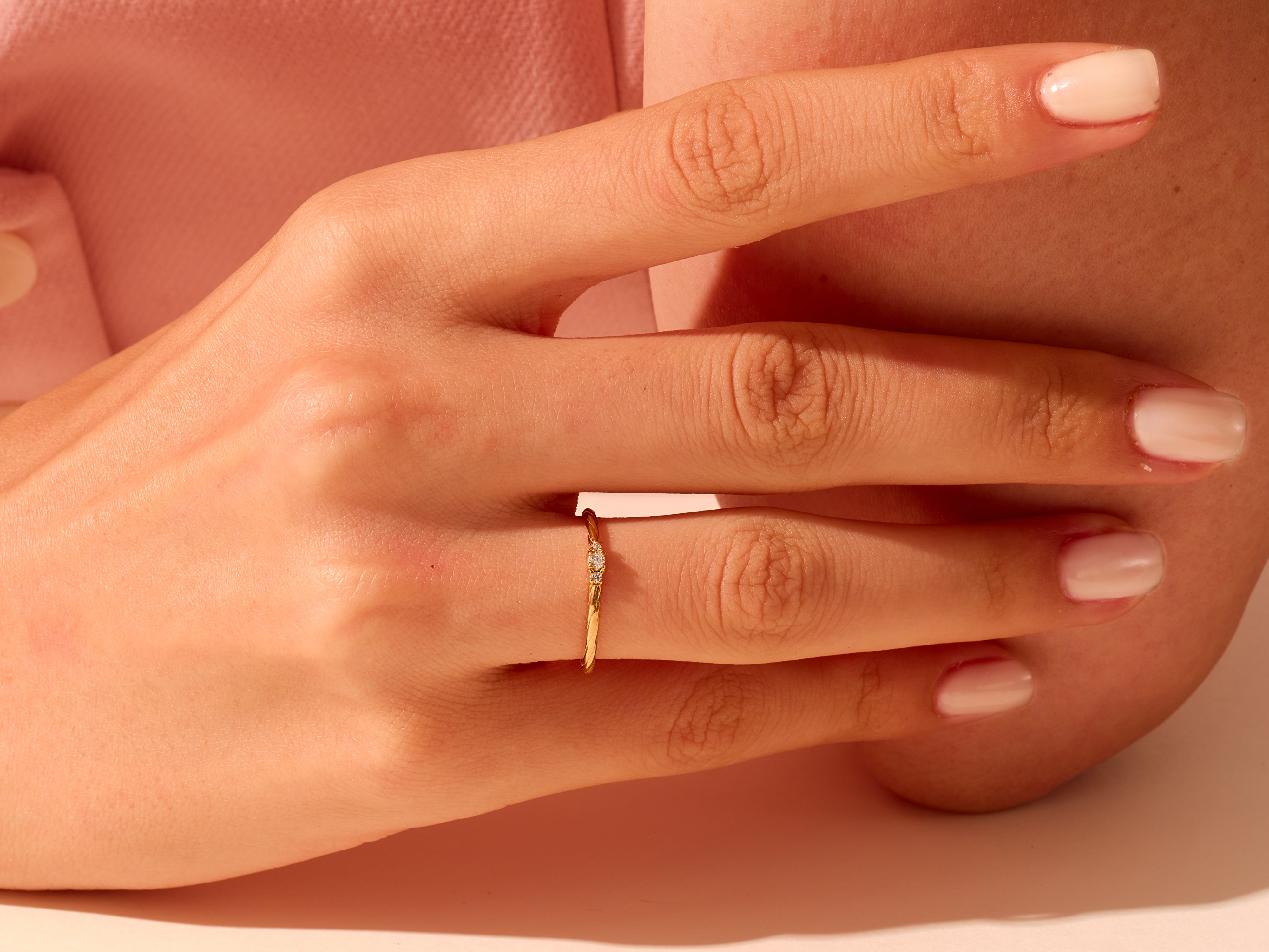 Delicate gold ring with diamonds on a woman's finger