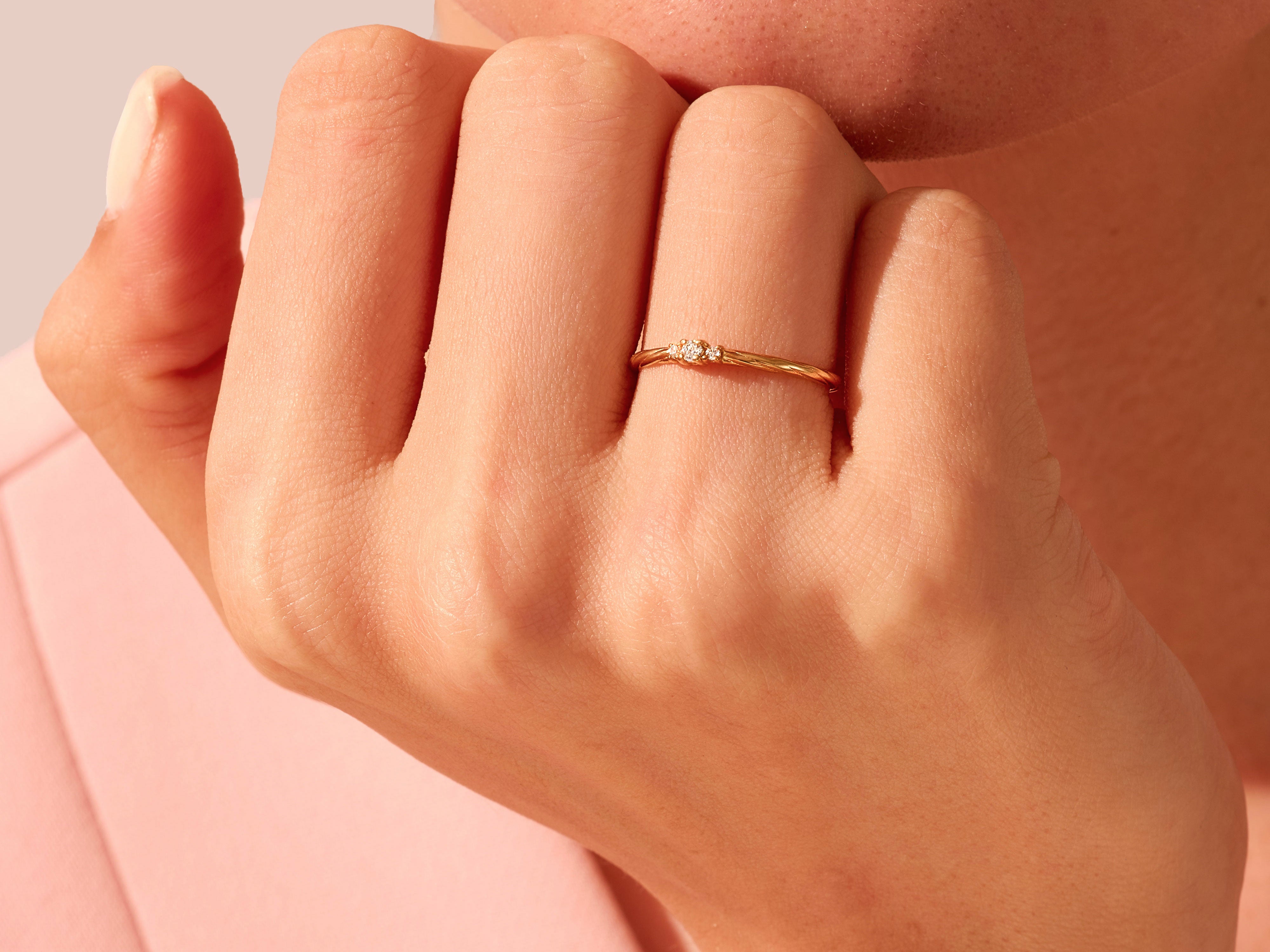 Delicate gold ring with three diamonds on a hand