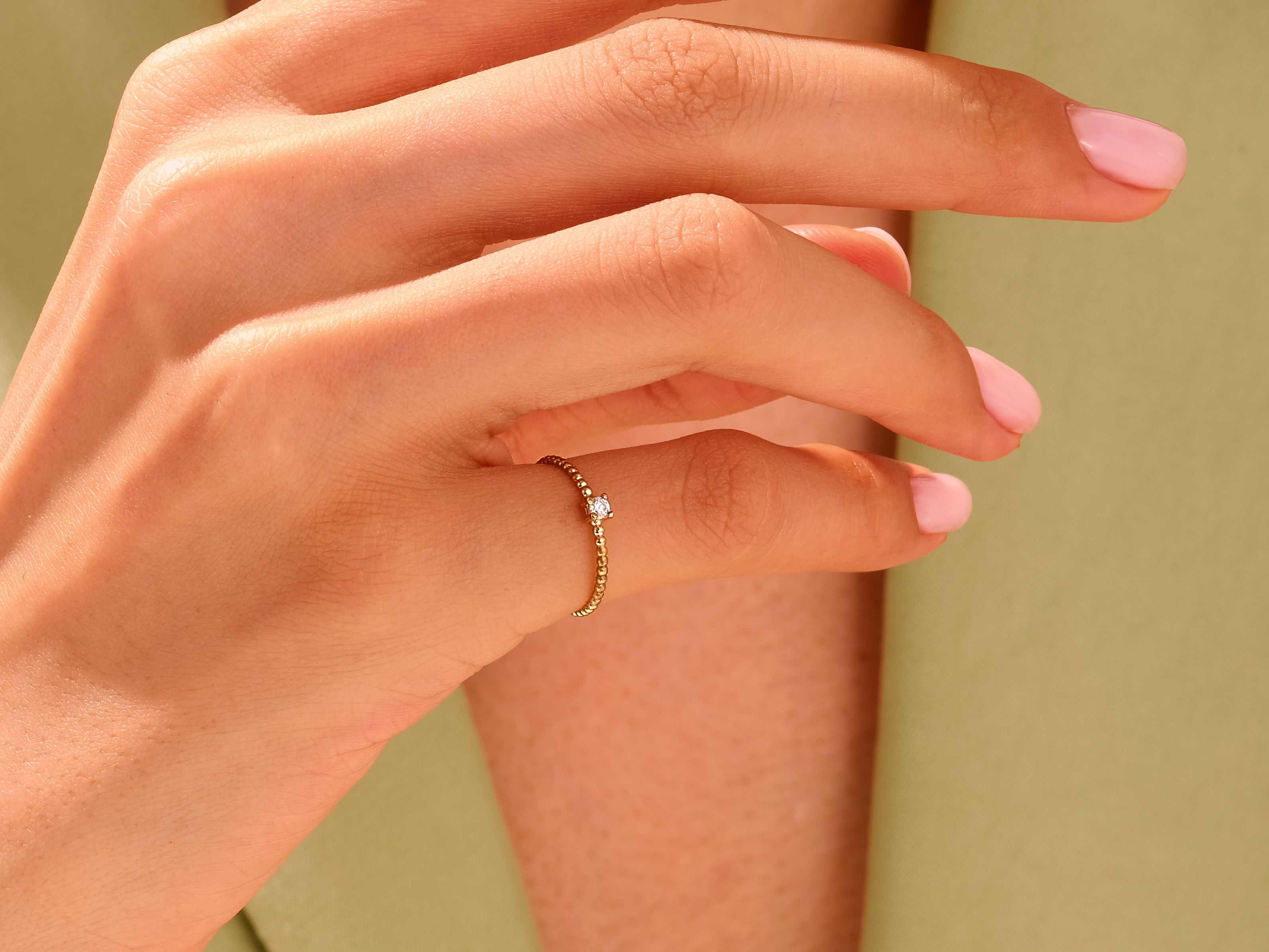 Delicate gold ring with diamond on a woman's finger