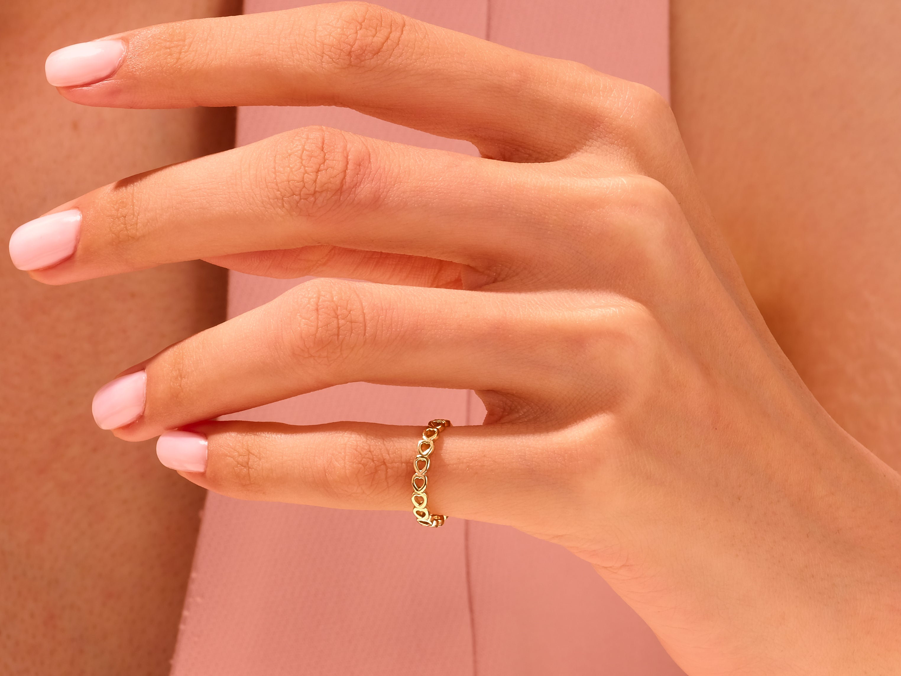 Gold heart ring on a woman's finger, jewelry