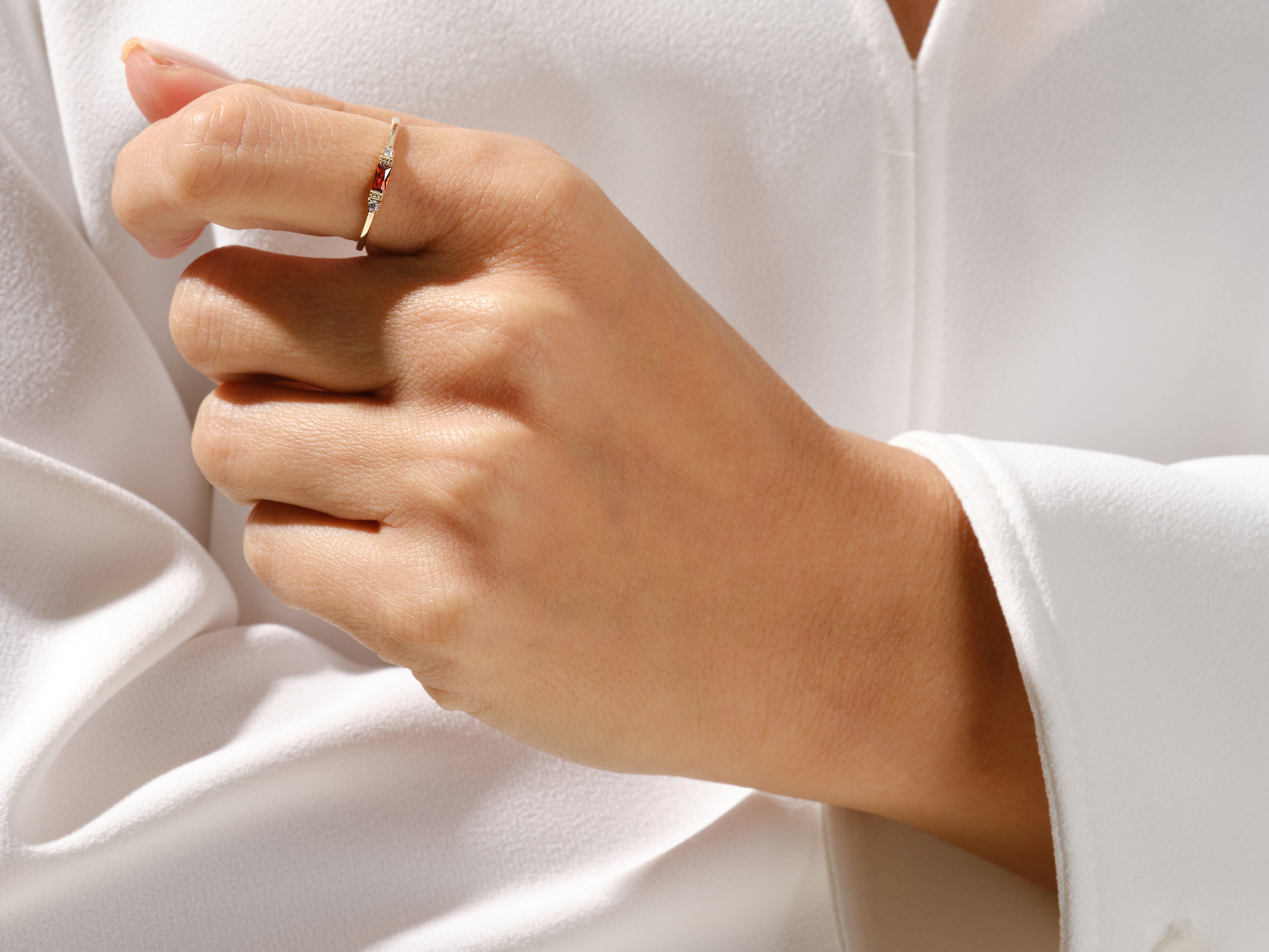 Gold ring with ruby and diamonds on a hand