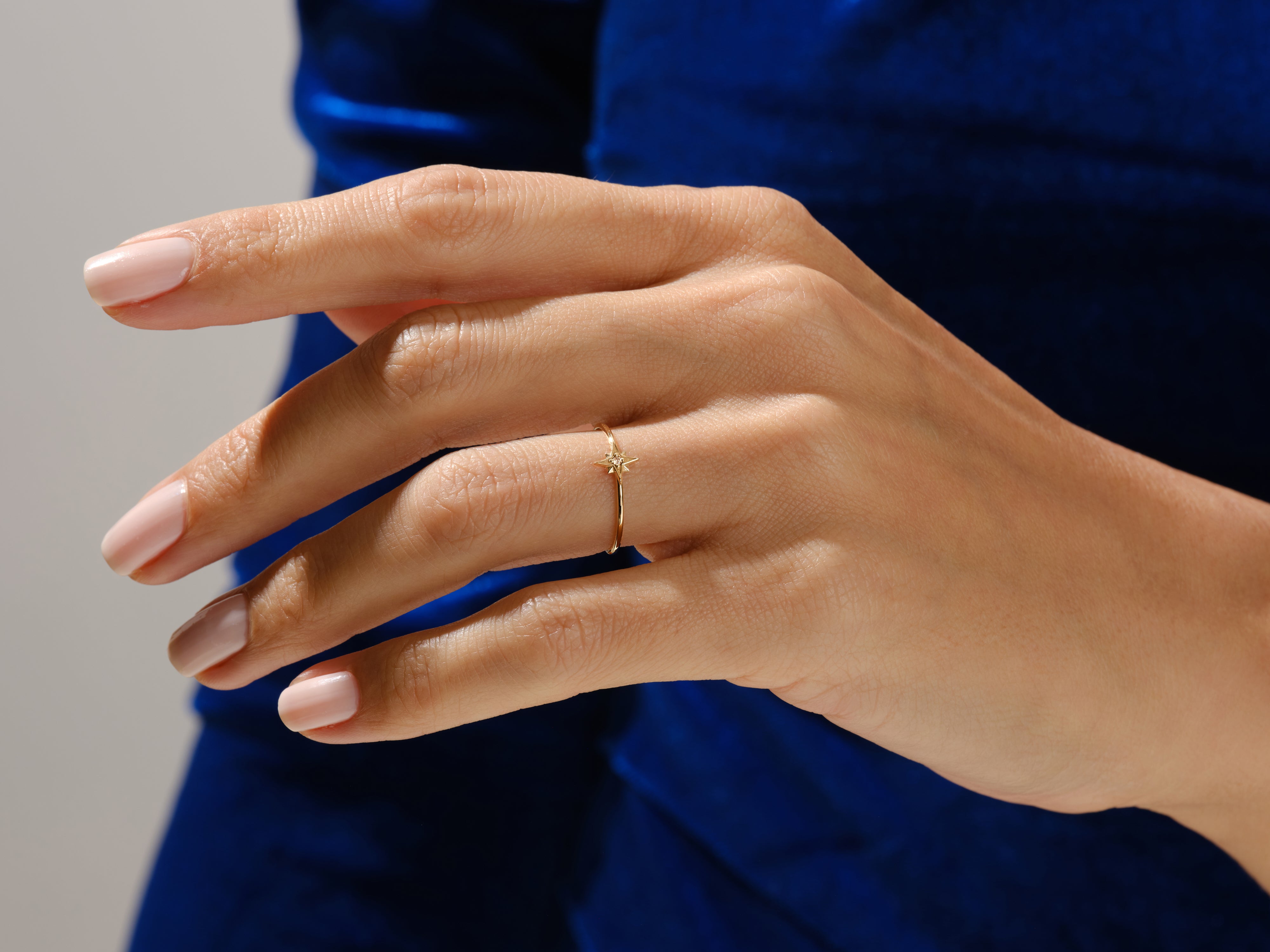 Delicate gold ring with star detail on a woman's finger