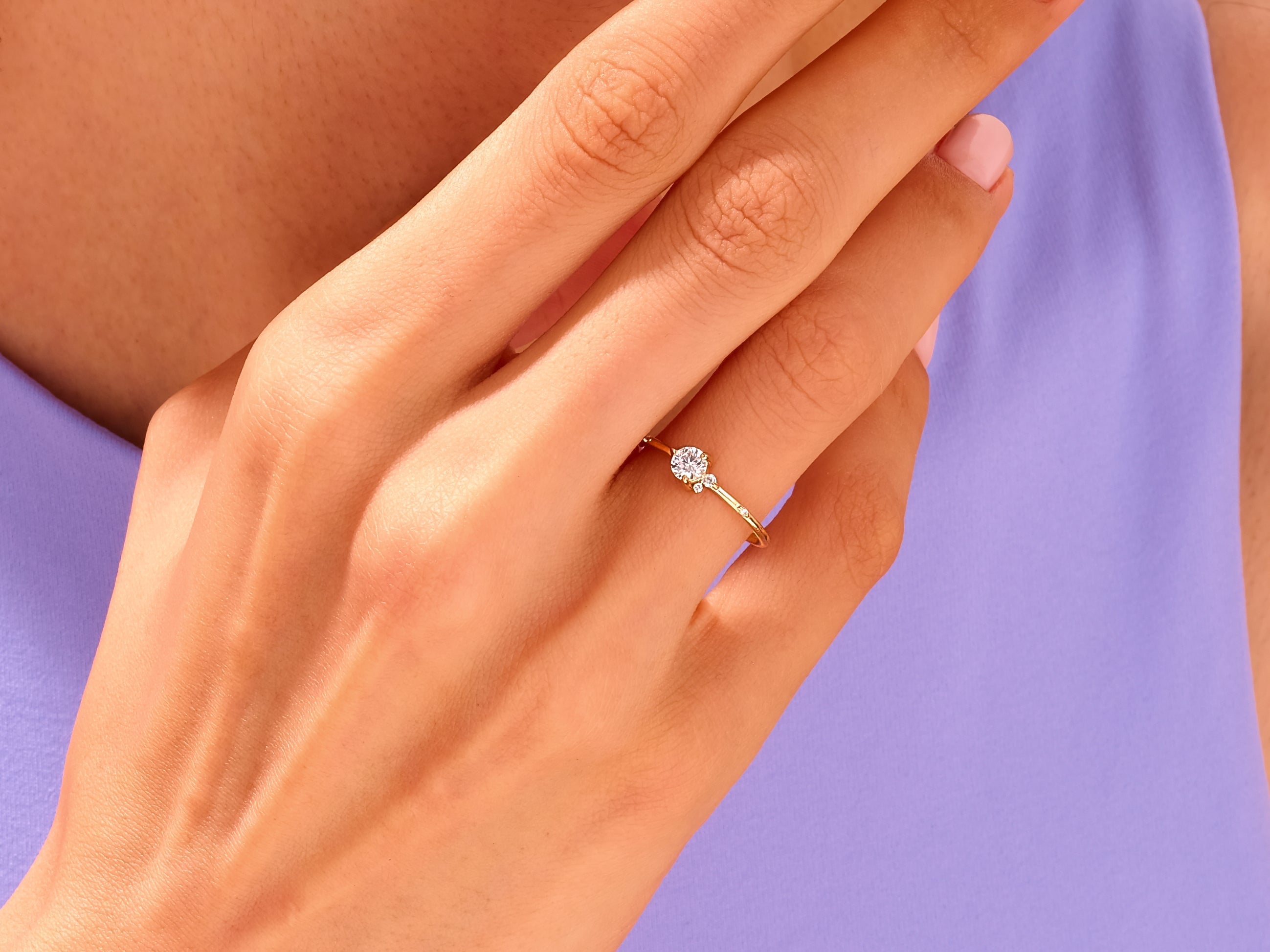 Delicate gold ring with diamond accents on a woman's hand