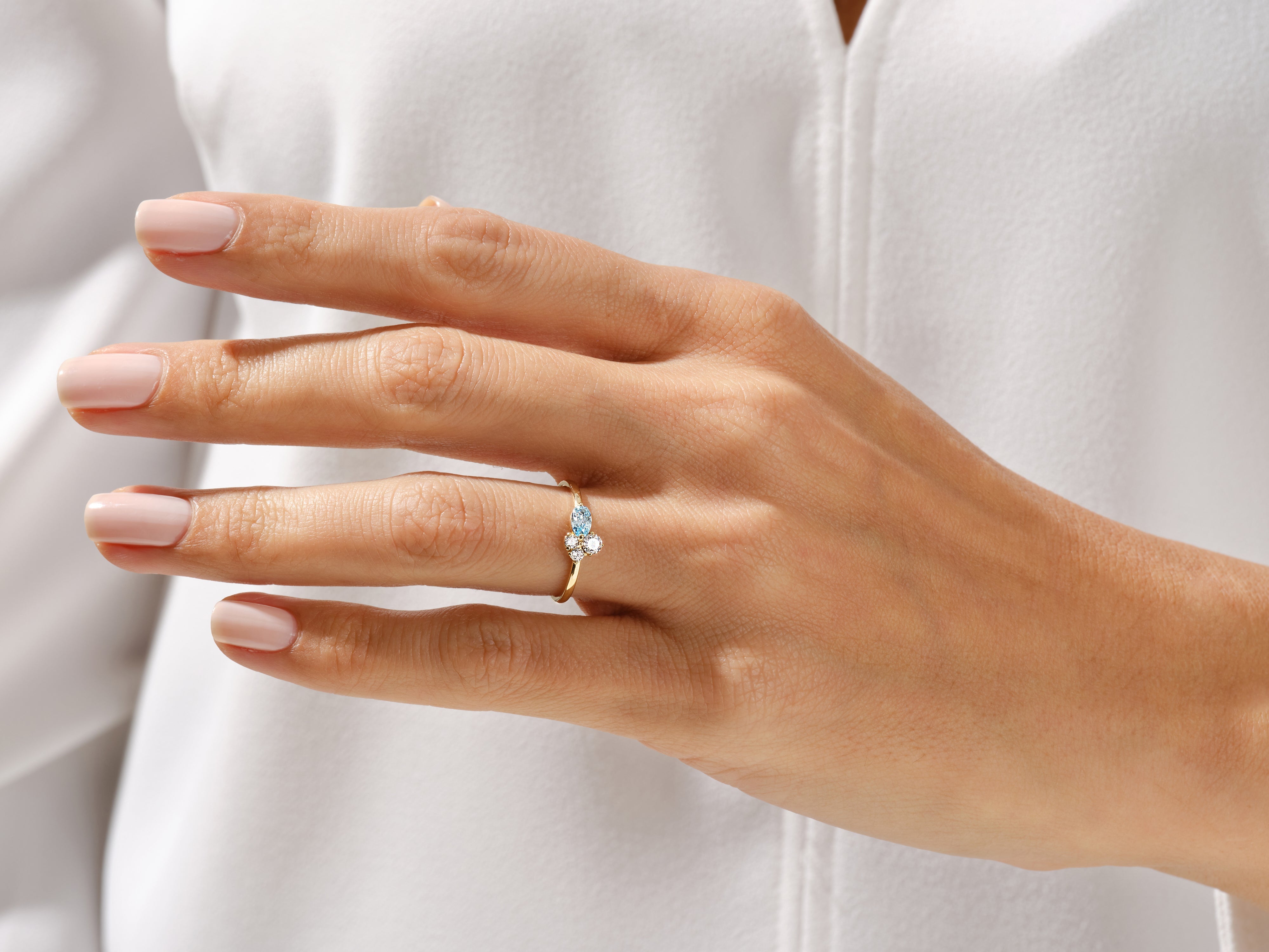 Gold ring with aquamarine and diamond accents on a woman's finger