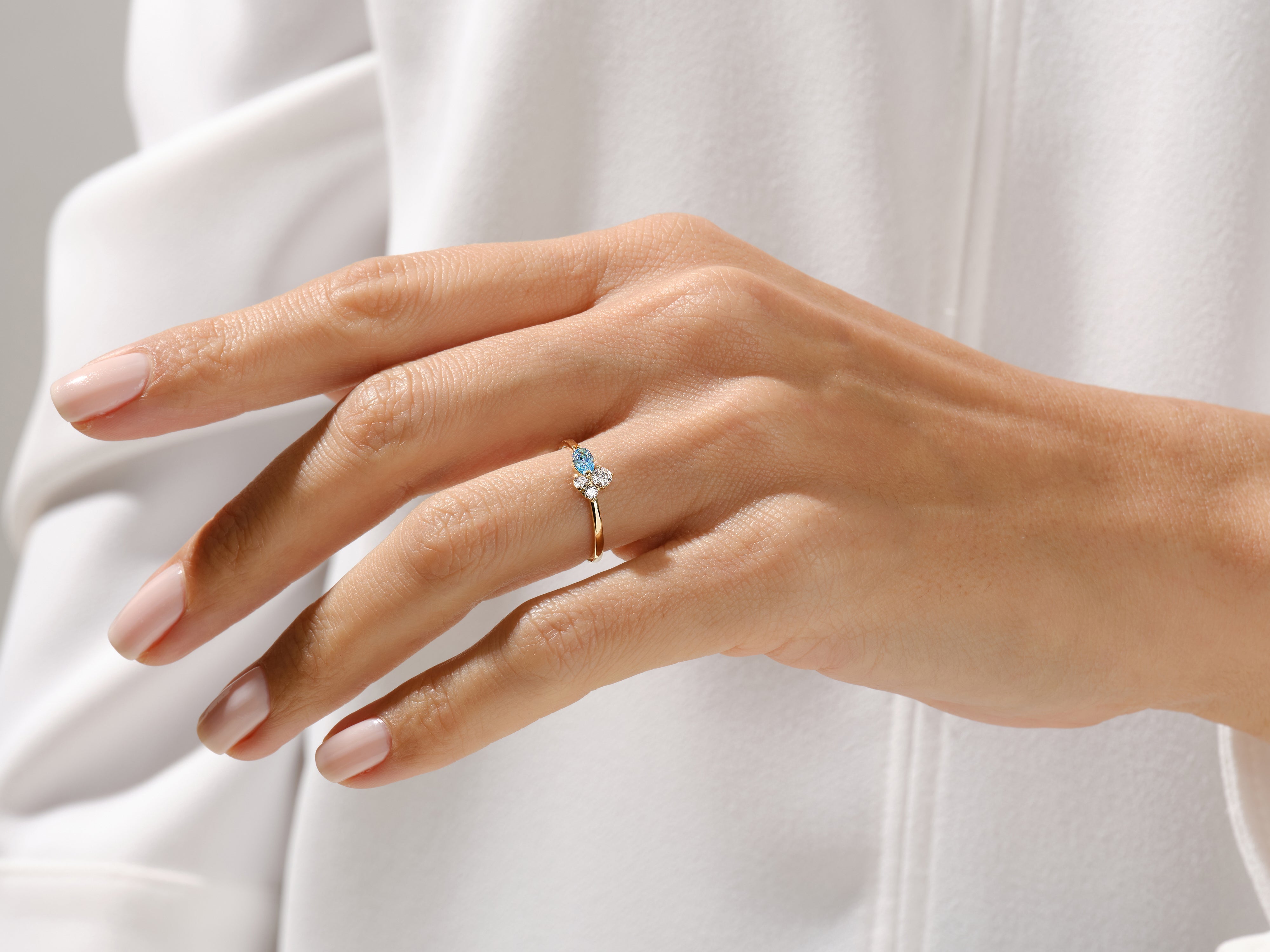 Gold ring with blue gemstone and diamonds on a woman's hand
