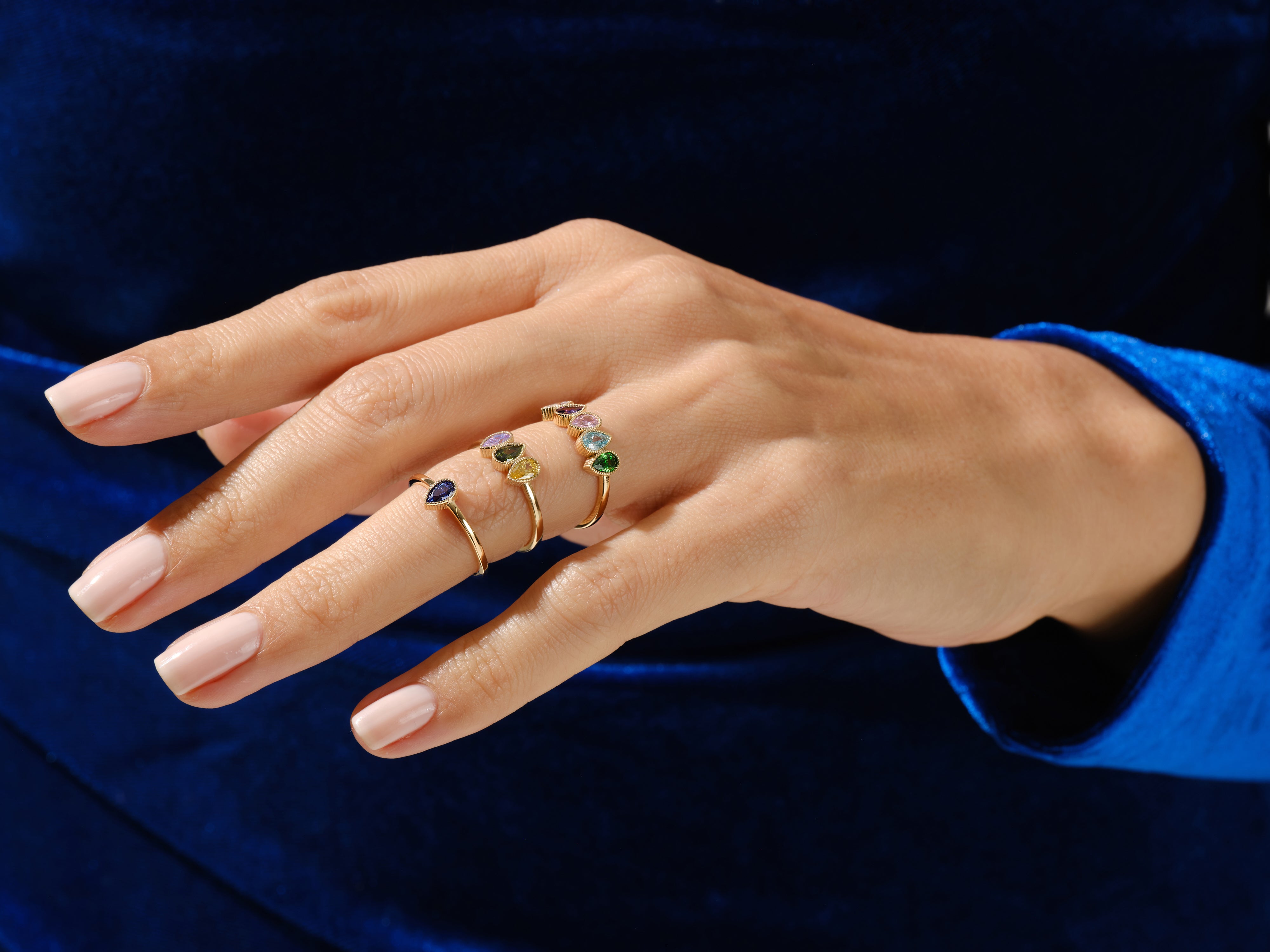 Gold rings with colorful gemstones on a hand